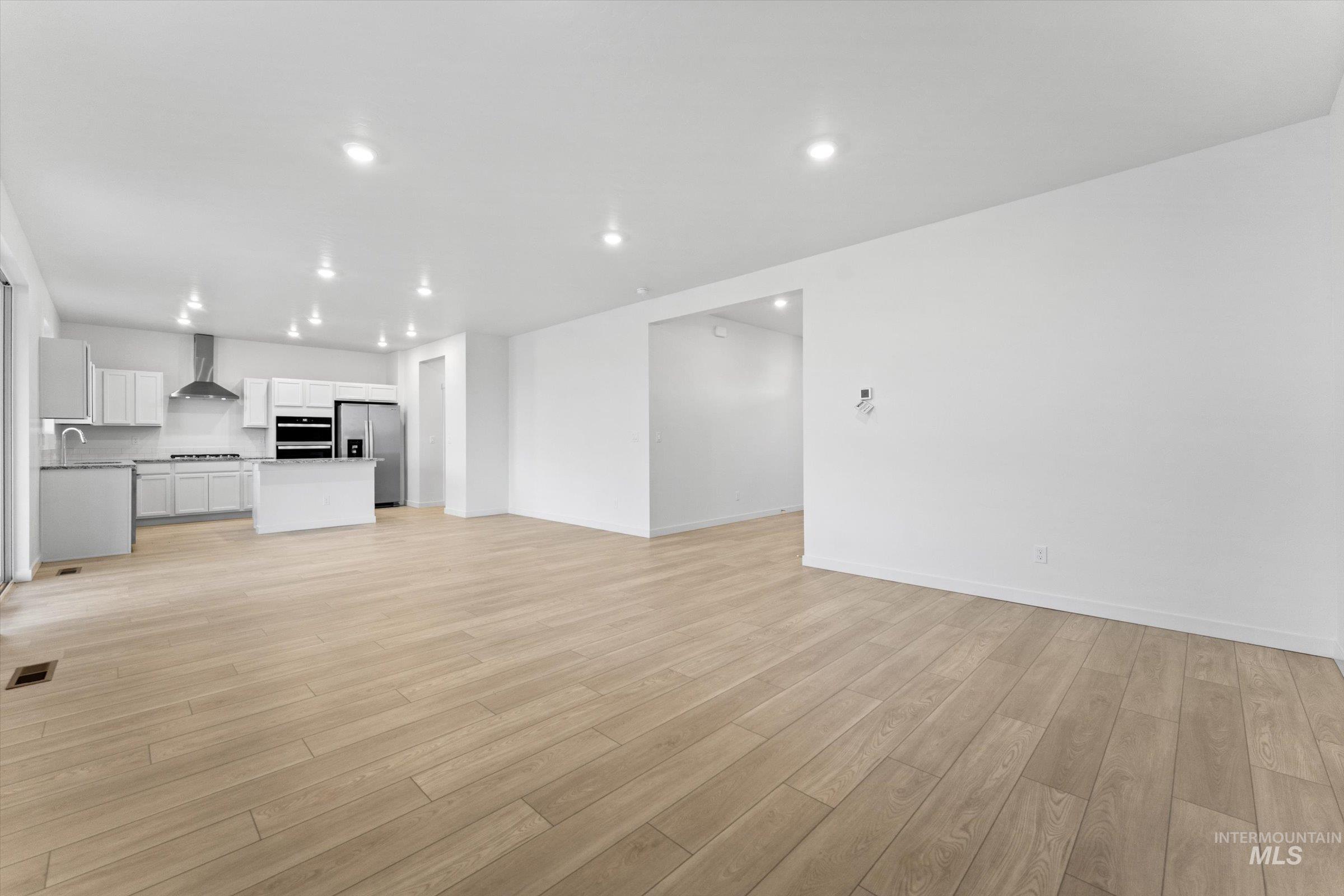 Unfurnished living room featuring light wood-style flooring and recessed lighting