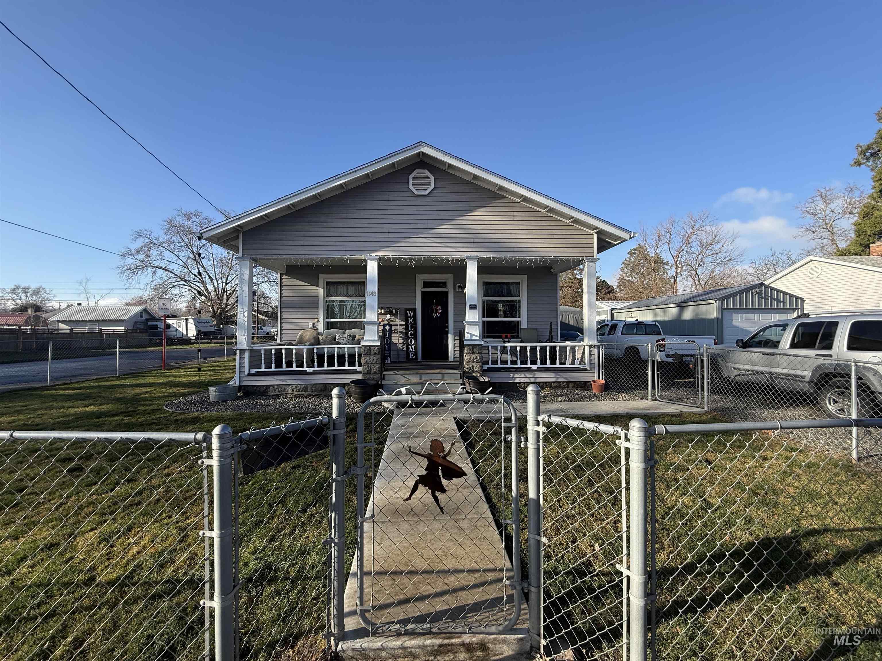 Shotgun-style home featuring a gate, a porch, and a fenced front yard