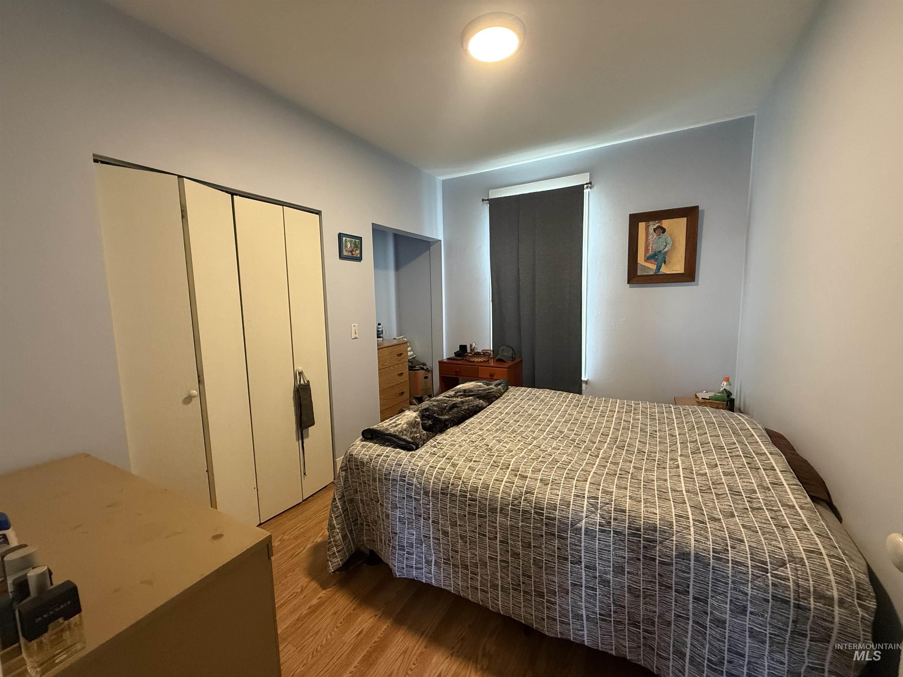 Bedroom with wood finished floors and a closet