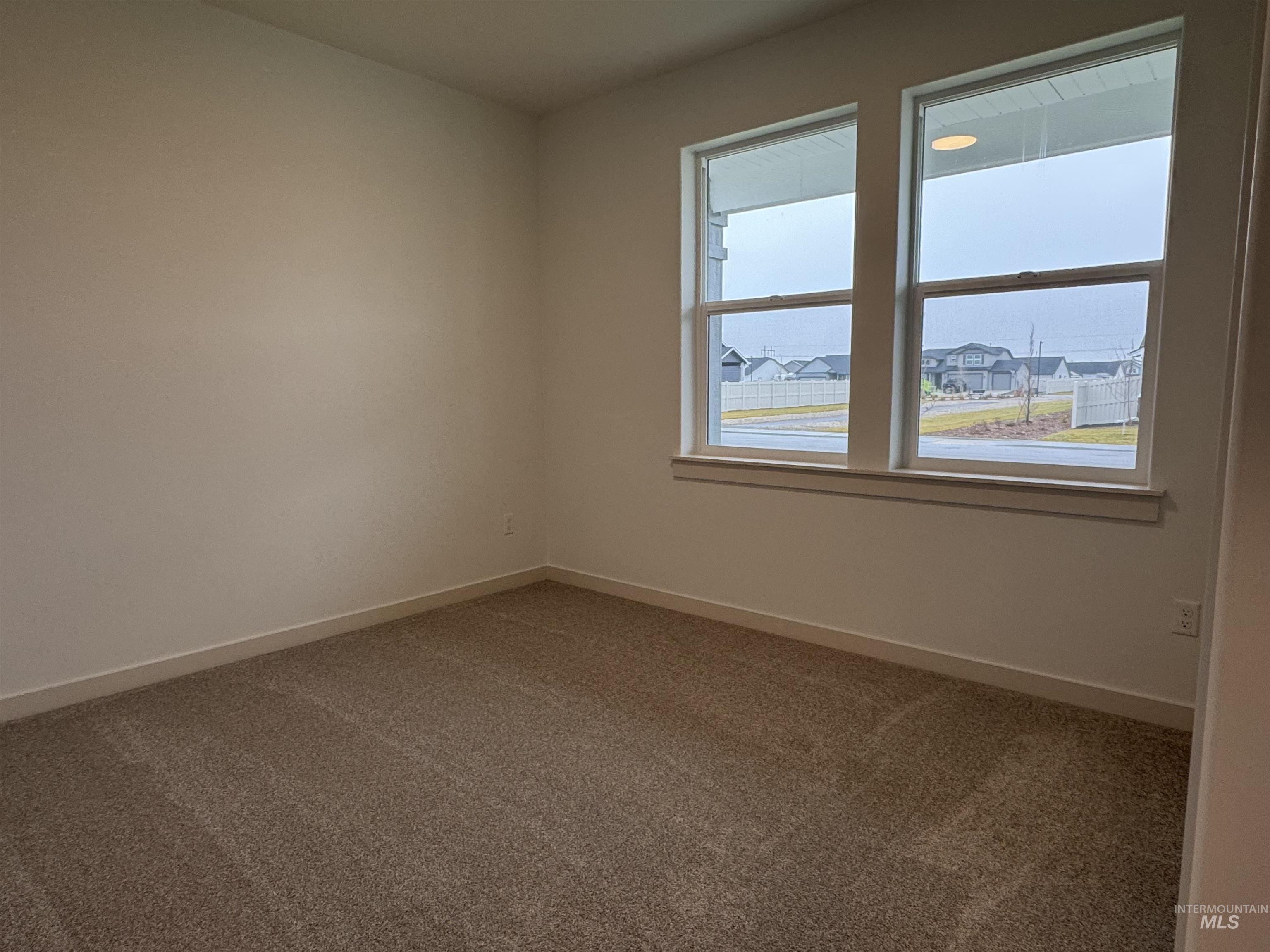 Carpeted spare room with baseboards