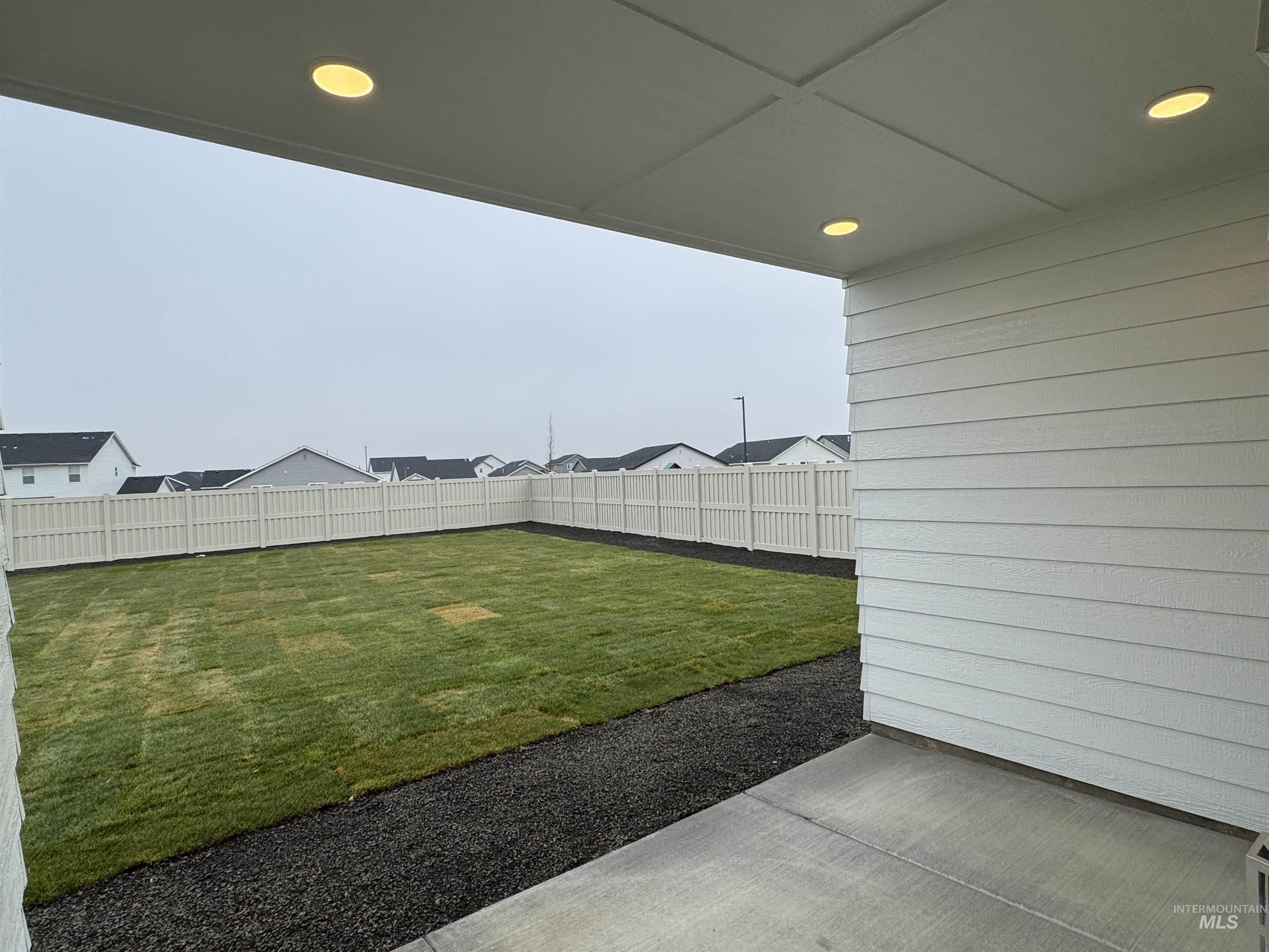 Fenced backyard with a patio area and a residential view