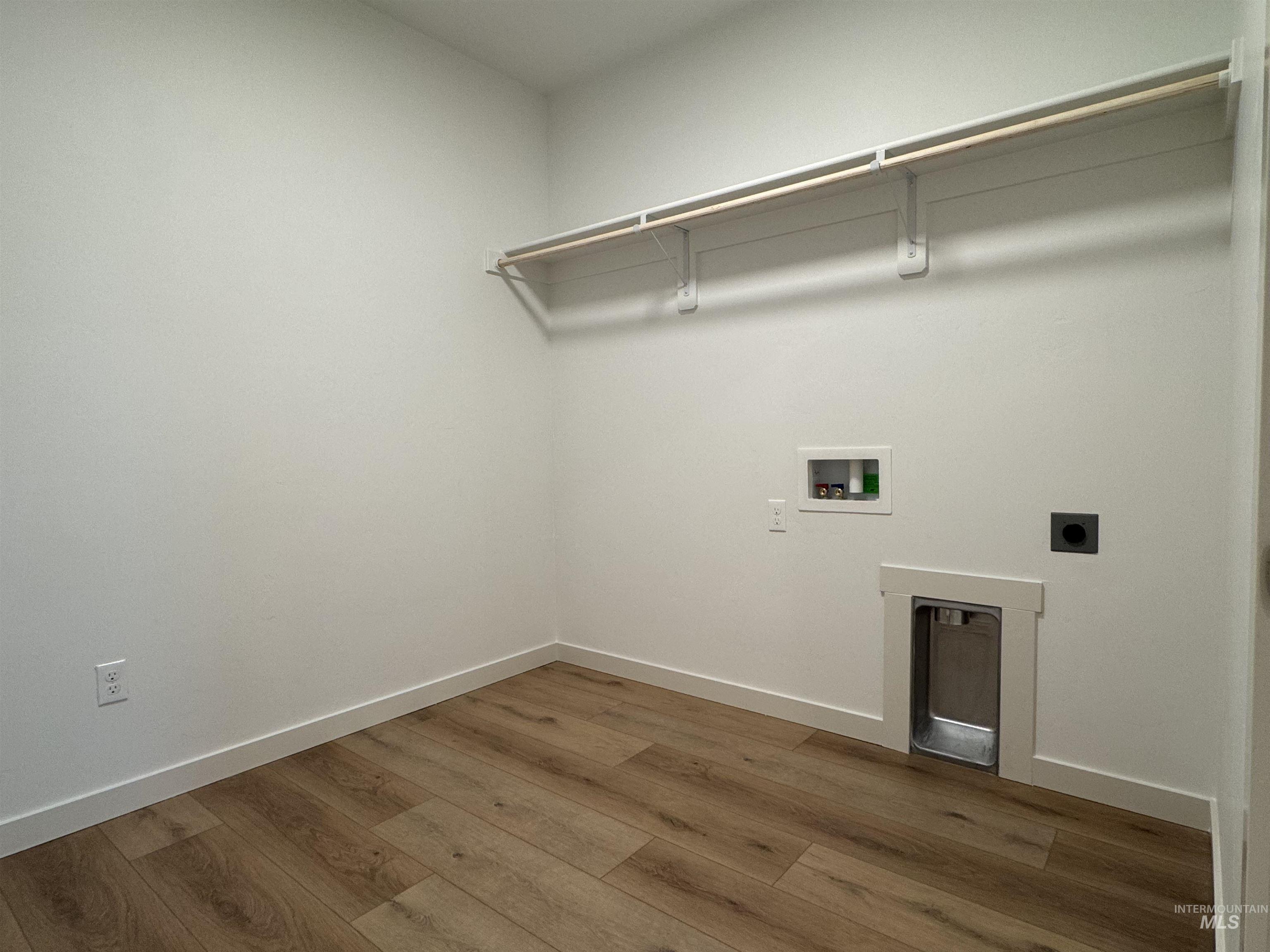Laundry room with electric dryer hookup, wood finished floors, and washer hookup