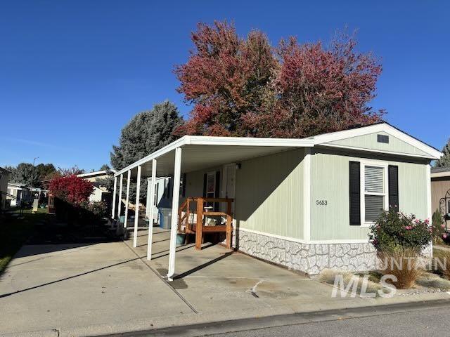 Manufactured / mobile home featuring an attached carport and concrete driveway