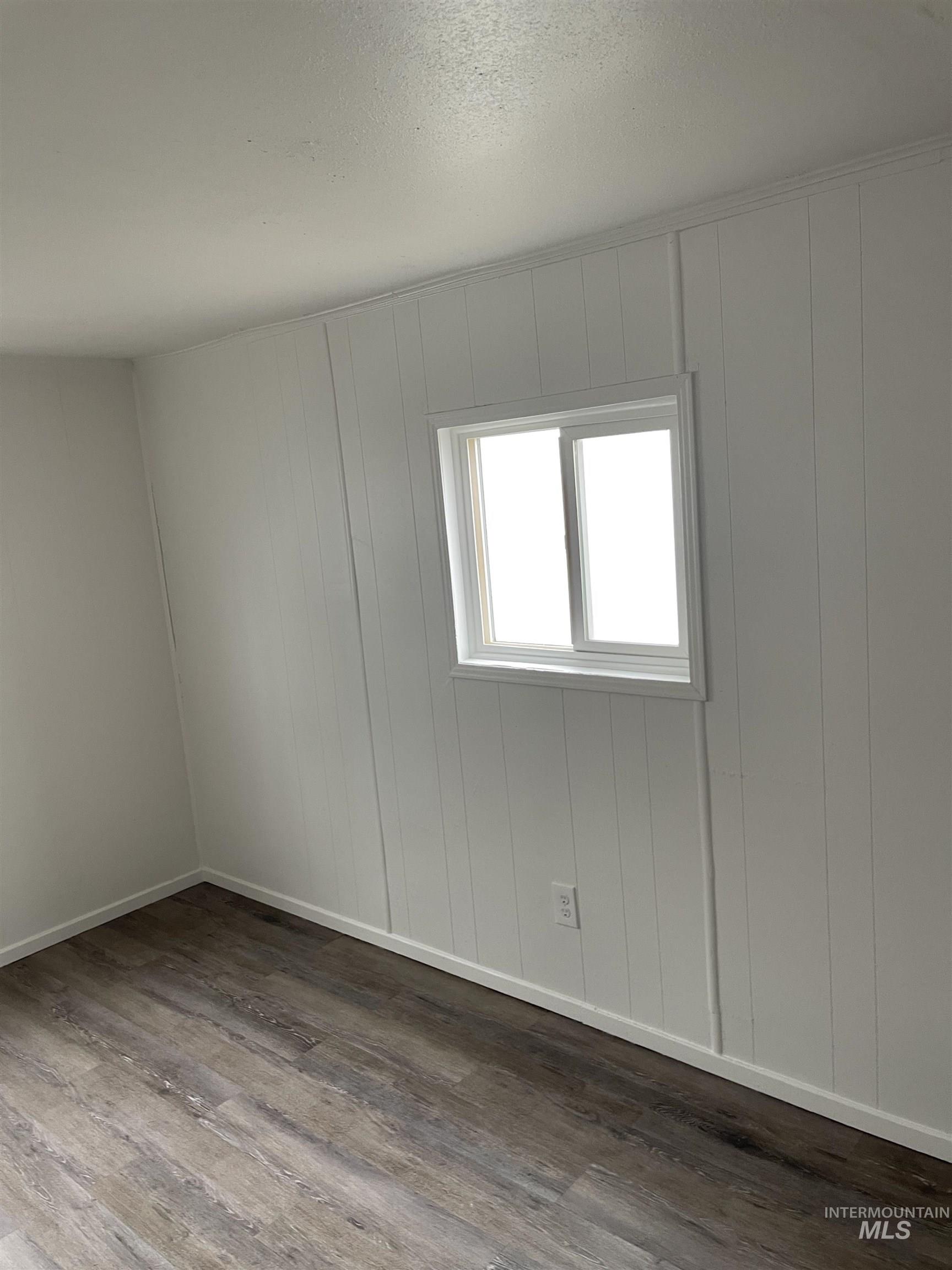 Spare room with wood finished floors and a textured ceiling