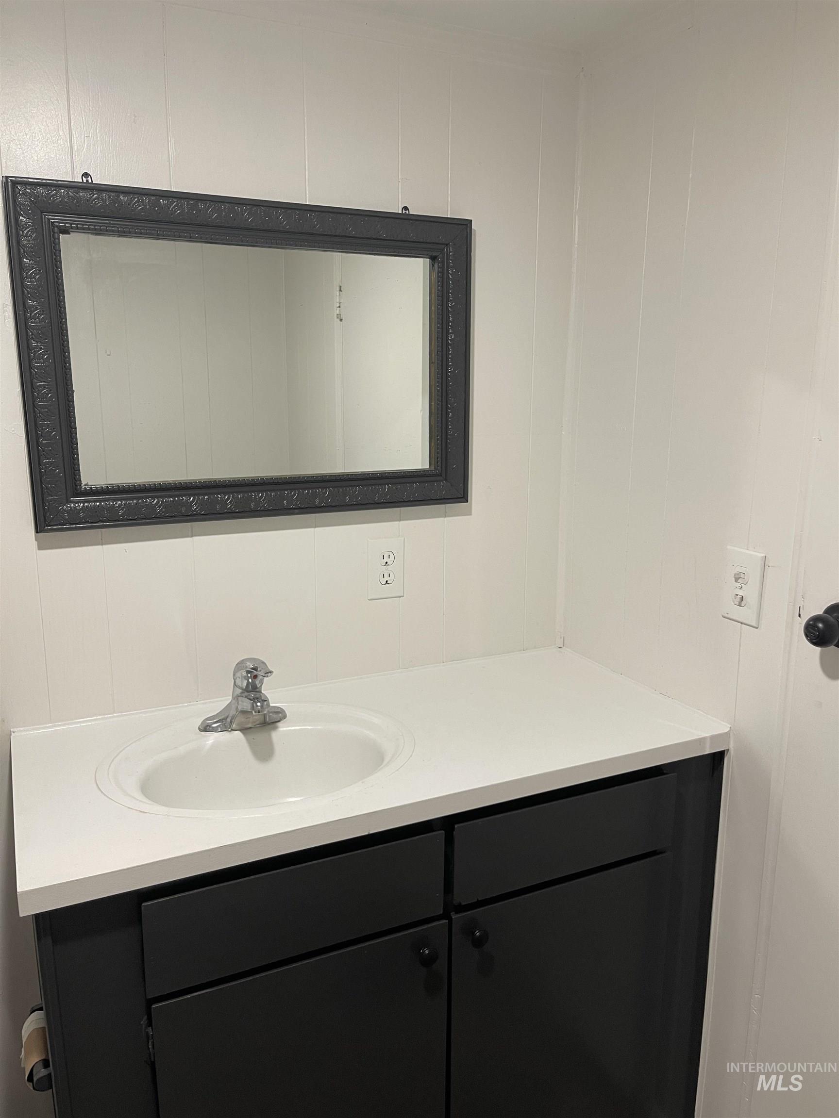 Bathroom featuring vanity and a decorative wall