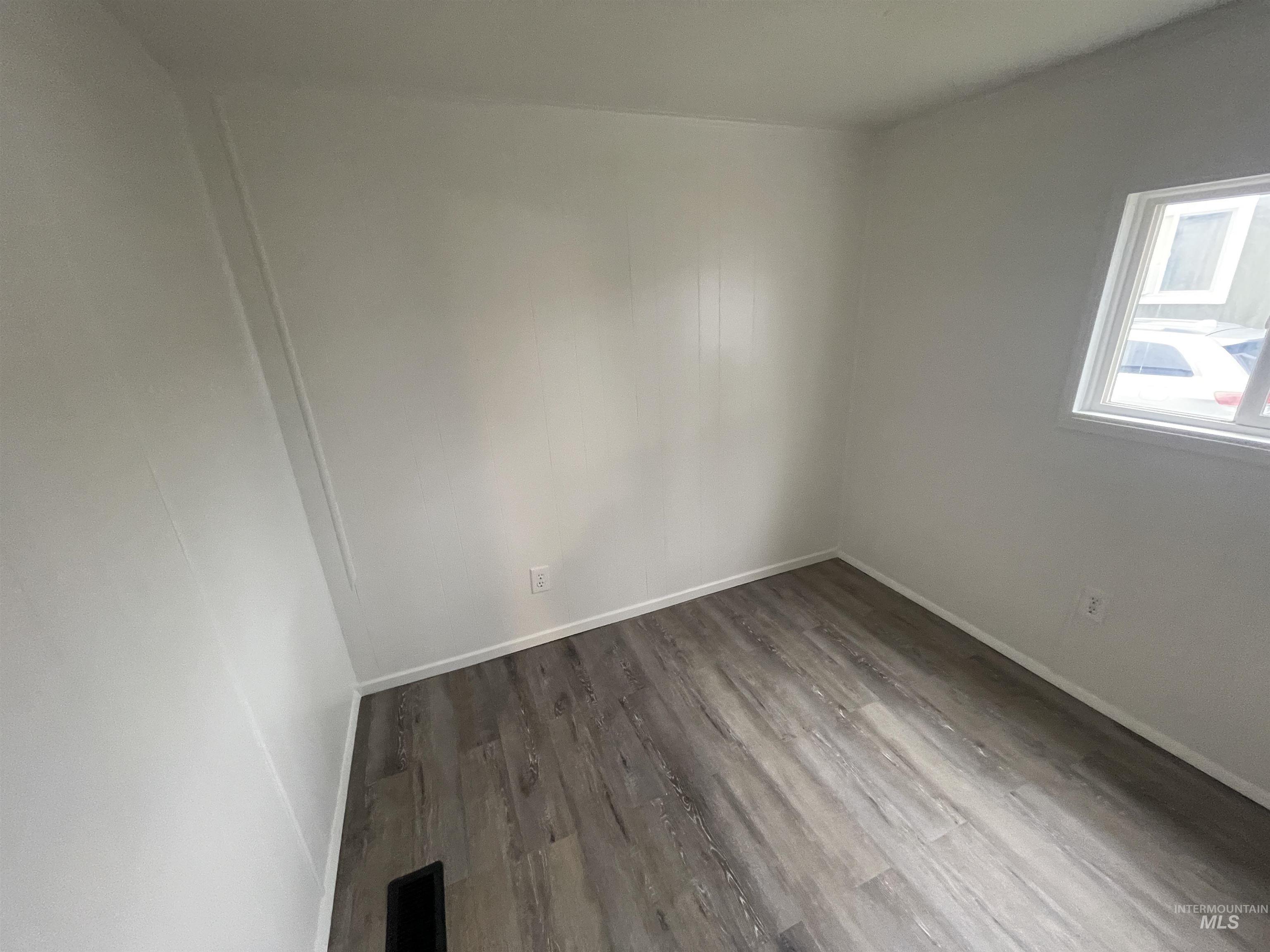 Empty room featuring wood finished floors and baseboards