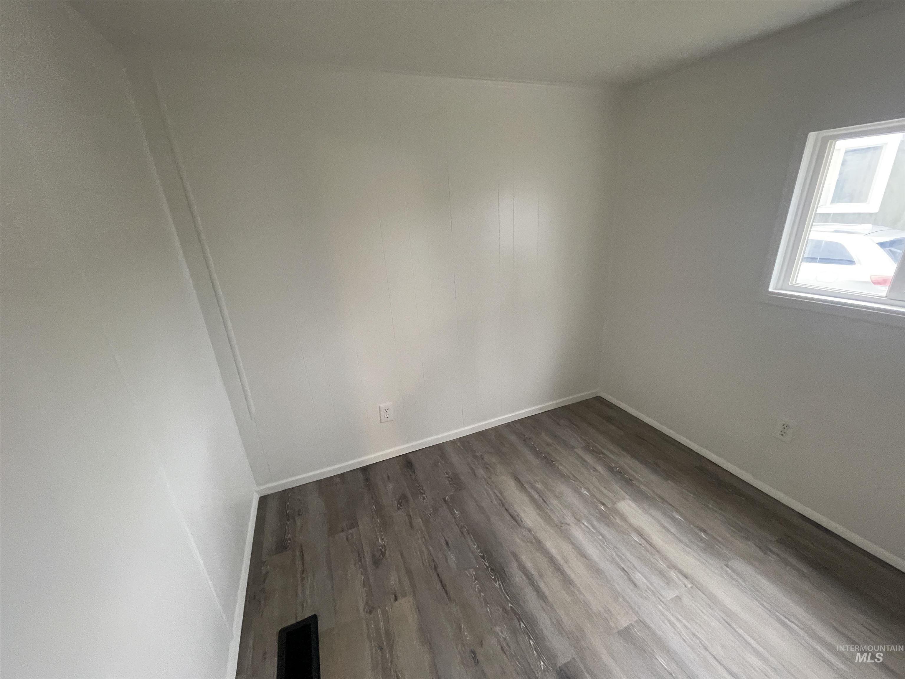 Spare room featuring wood finished floors and baseboards