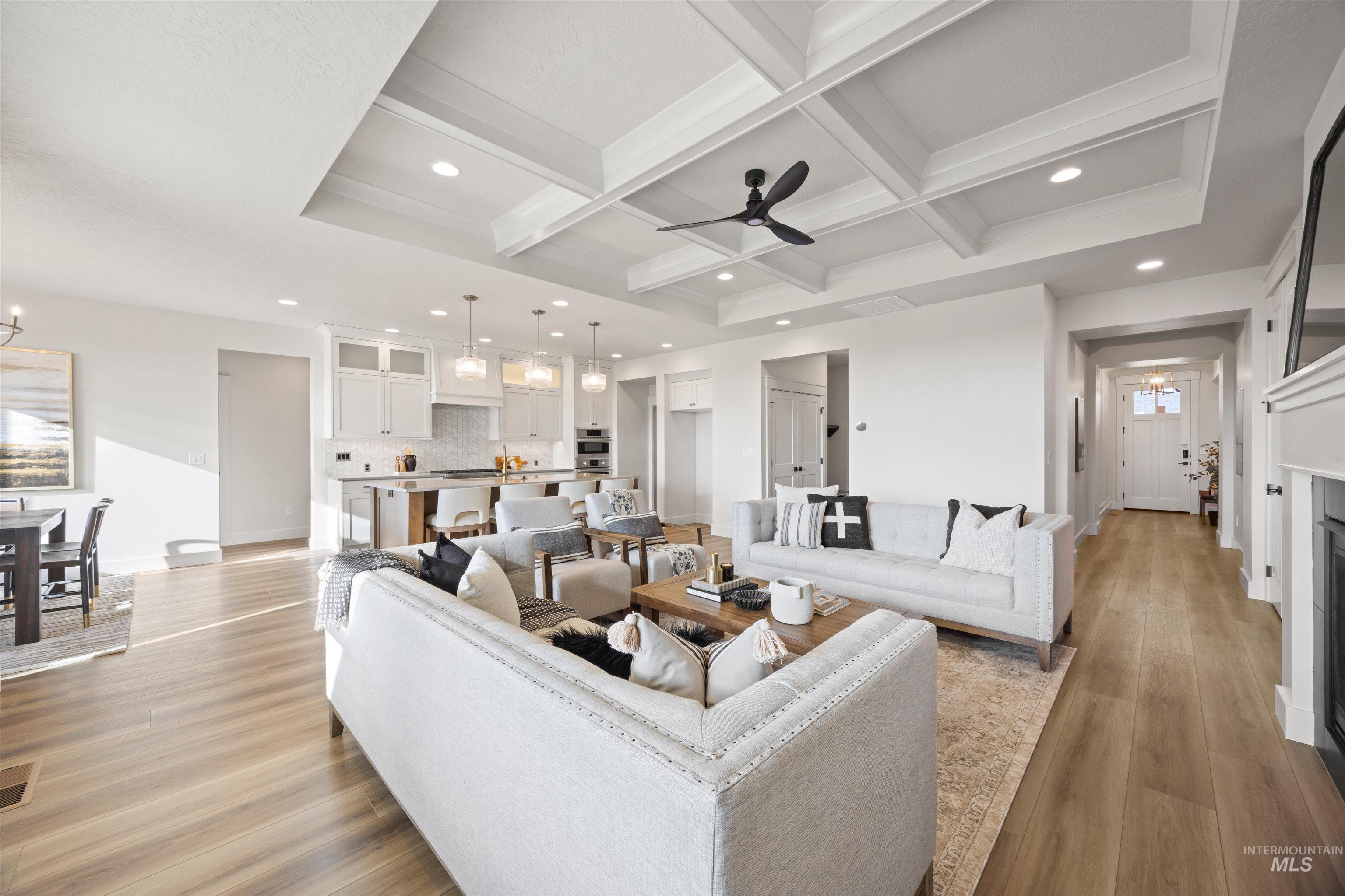 Living area featuring ceiling fan, coffered ceiling, recessed lighting, beam ceiling, and light wood-style floors