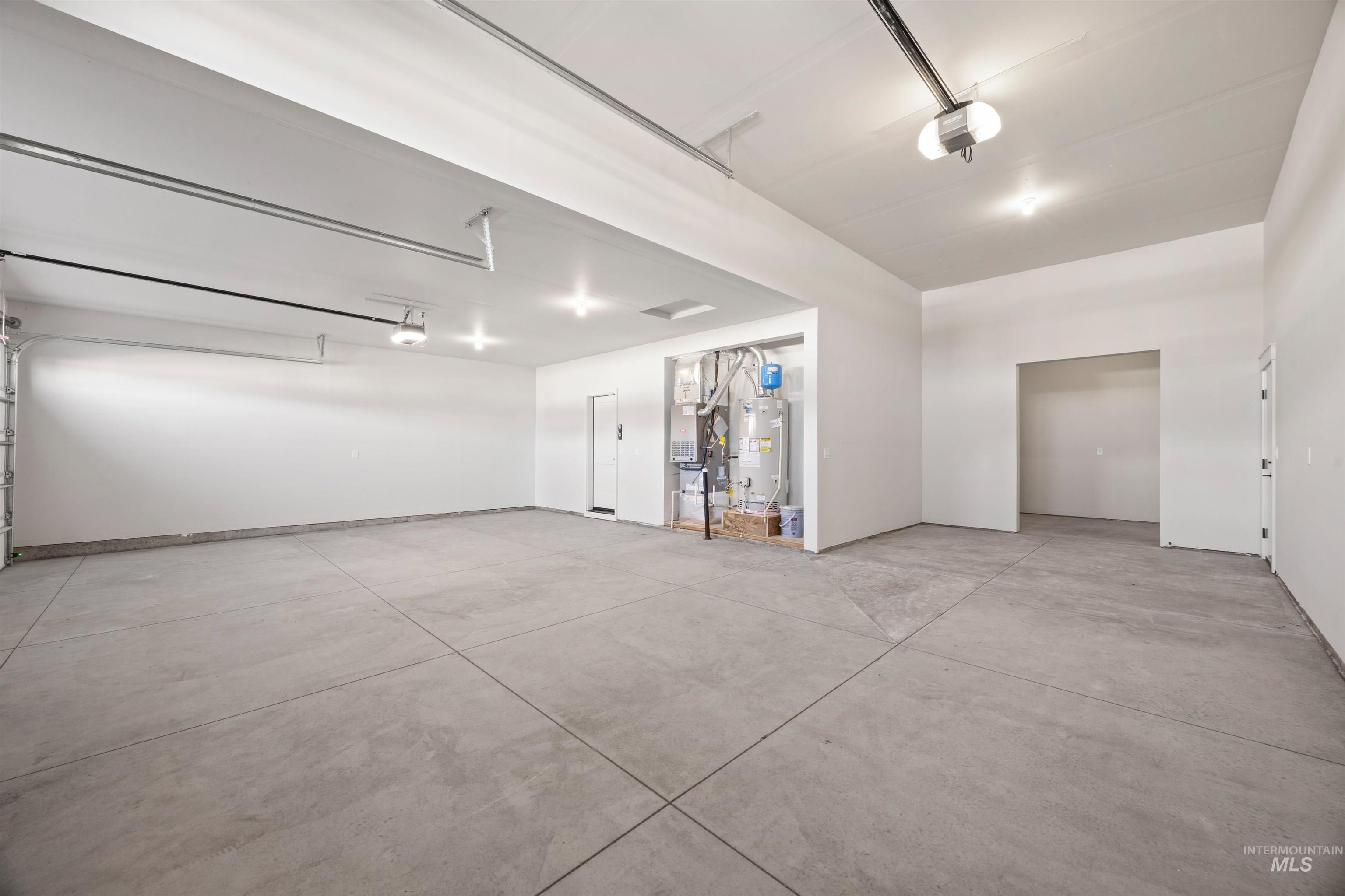 Garage with water heater, a garage door opener, and heating unit