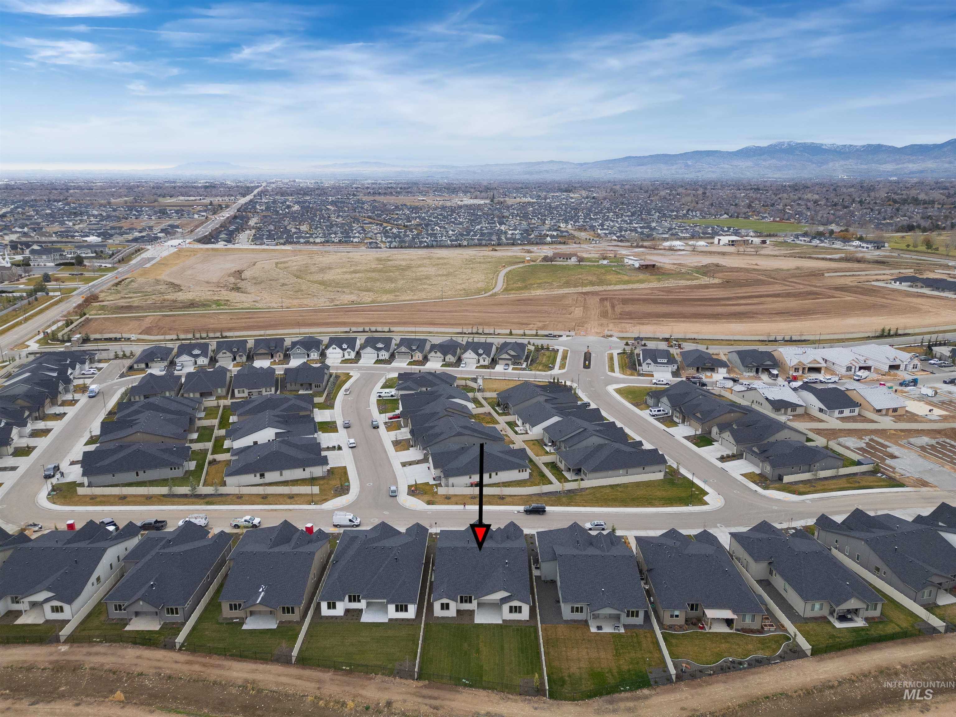 Aerial view of property and surrounding area with nearby suburban area and mountains