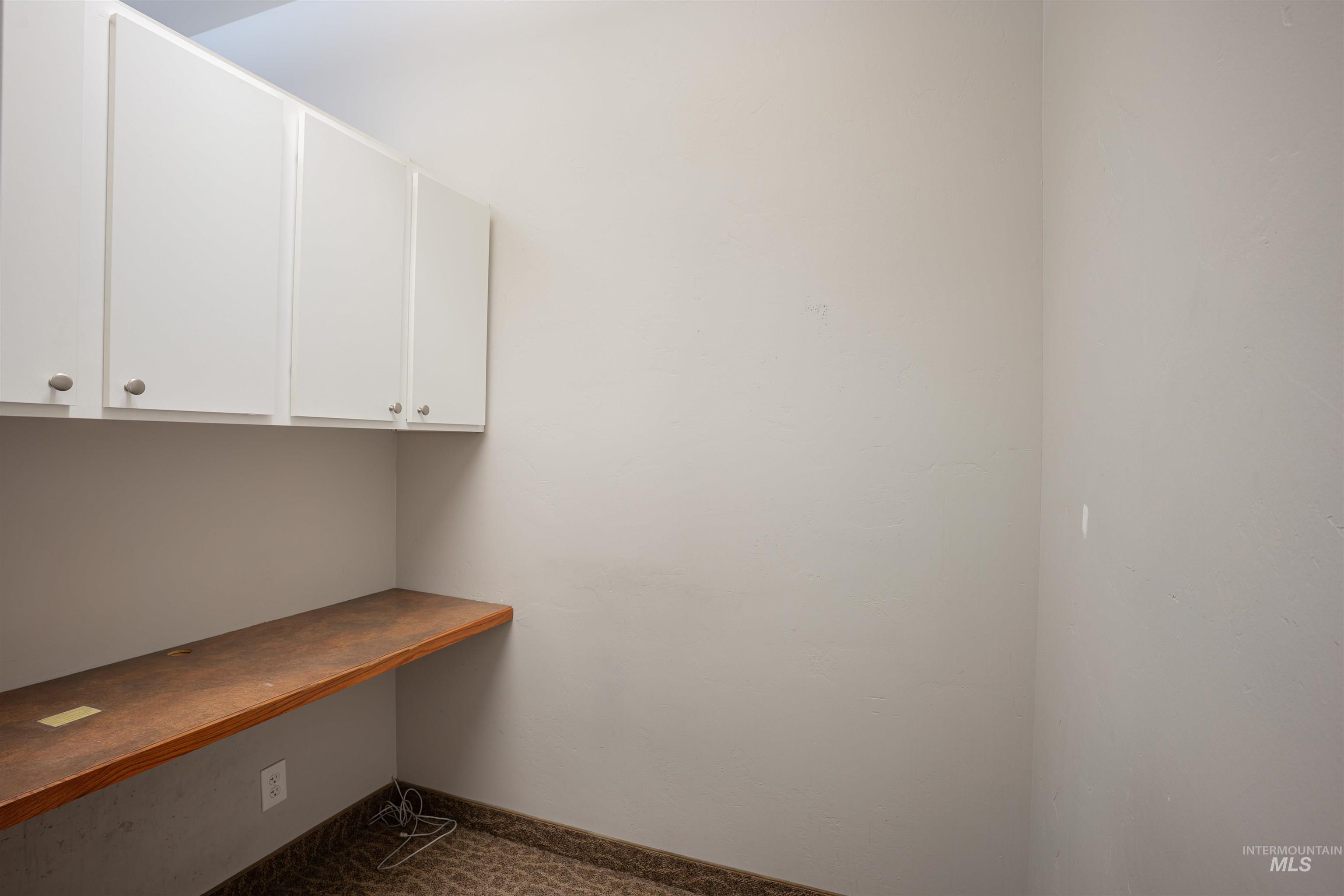 Unfurnished office with dark carpet and built in desk