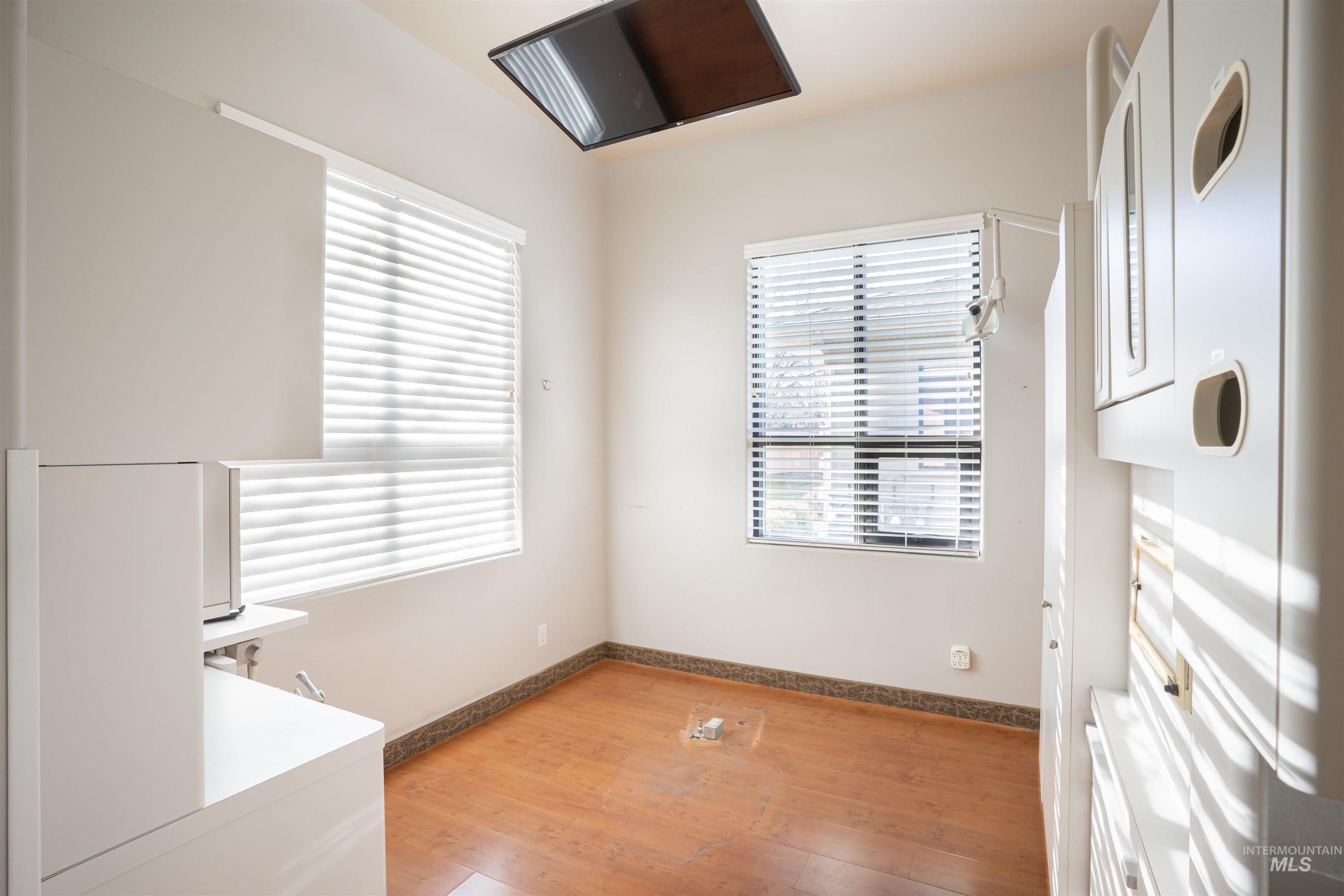 Unfurnished dining area featuring light wood-style flooring and baseboards
