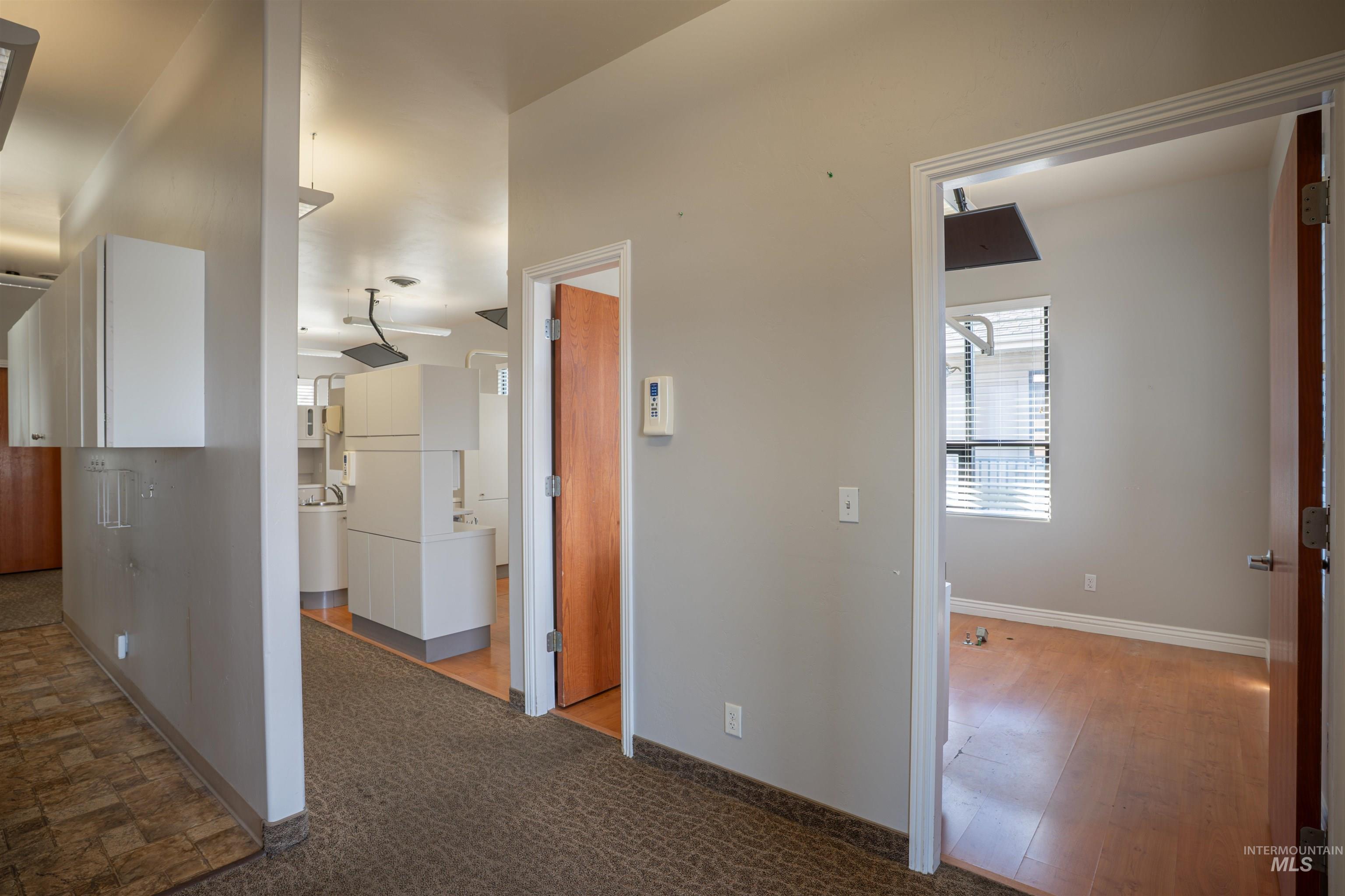 Corridor featuring carpet flooring and baseboards