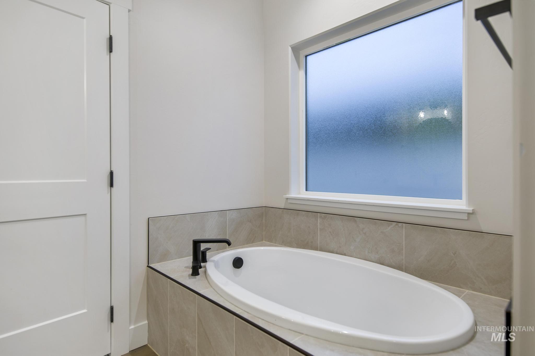 Full bath featuring a bath and healthy amount of natural light