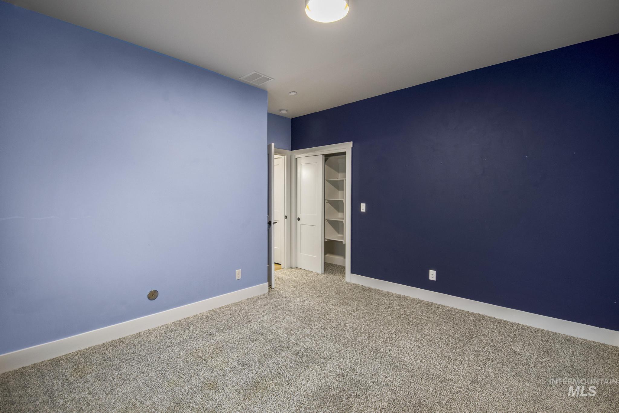 Unfurnished bedroom with carpet flooring and a spacious closet