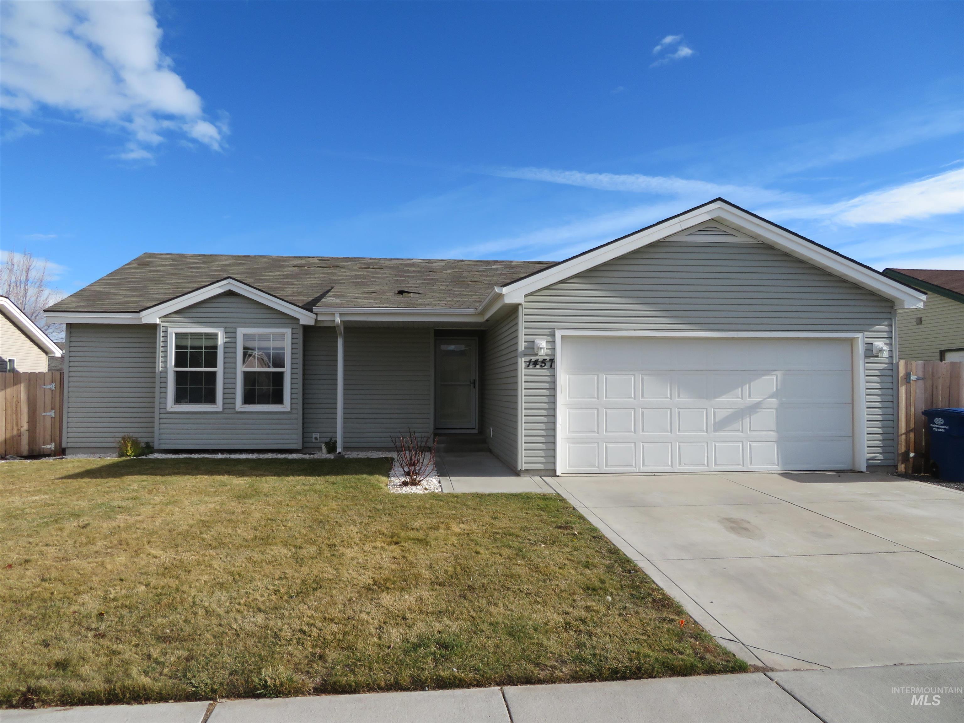 Single story home with concrete driveway, an attached garage, and roof with shingles