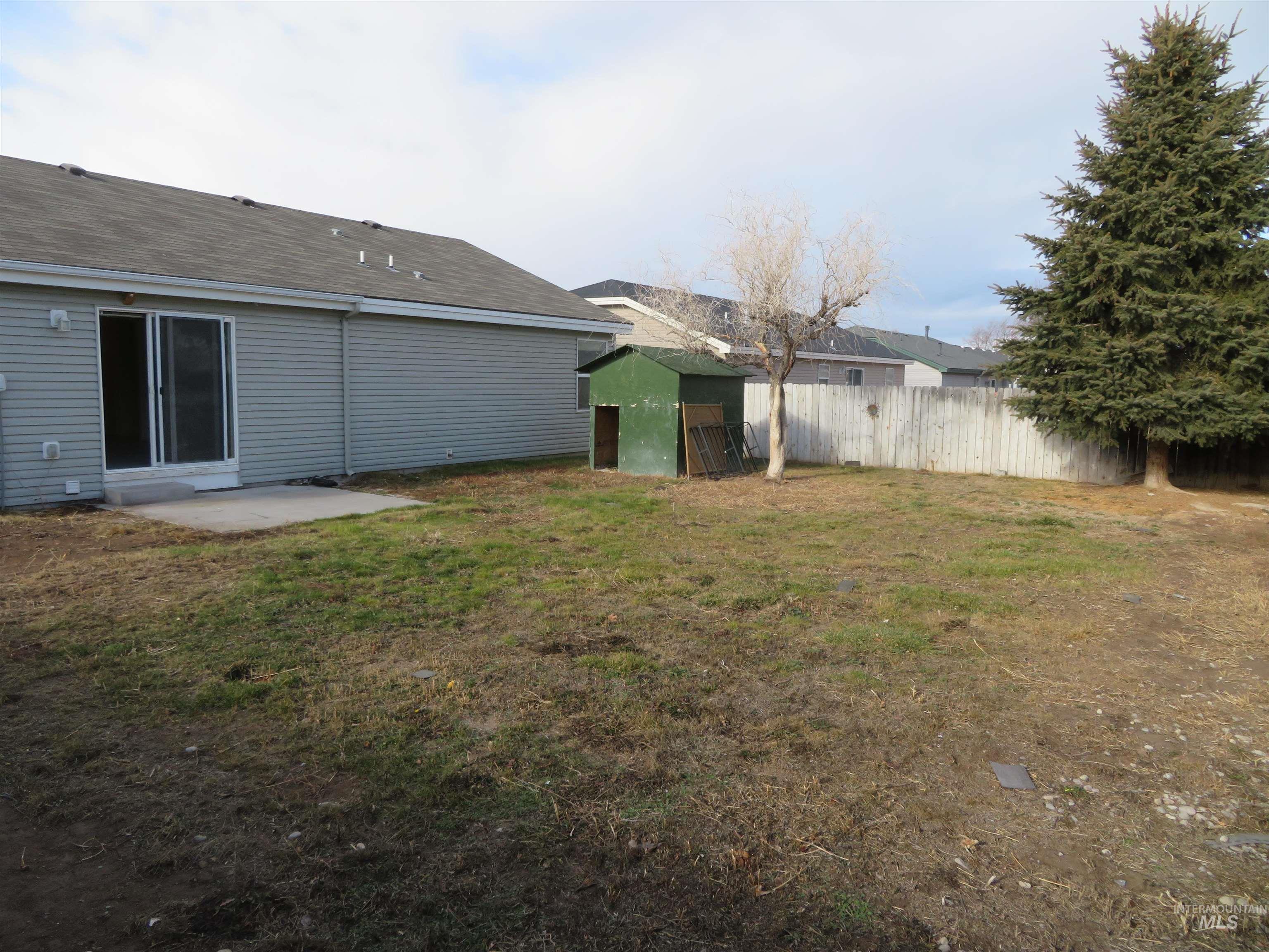 Rear view of property featuring a patio and a storage shed