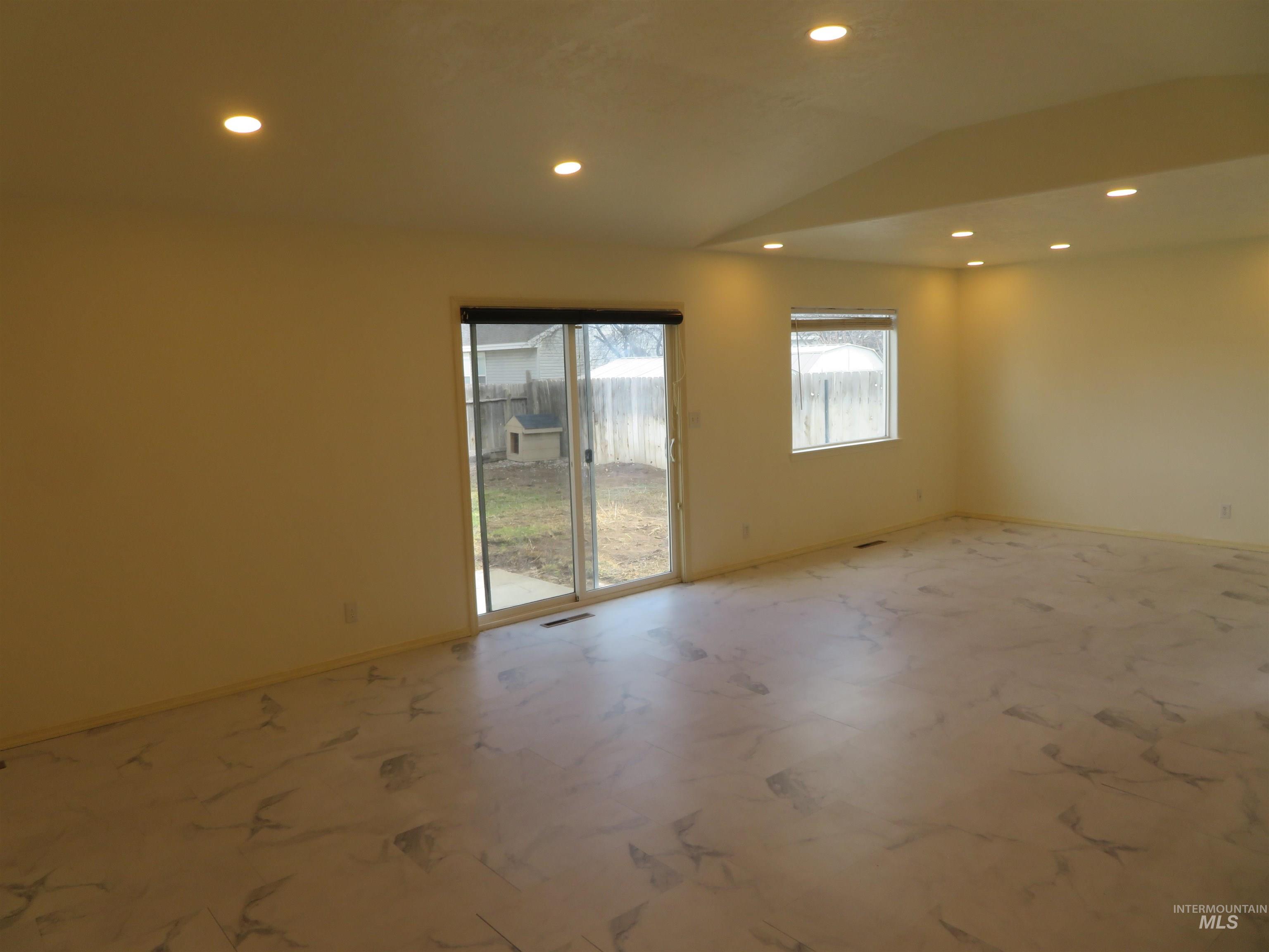 Unfurnished room with vaulted ceiling and recessed lighting