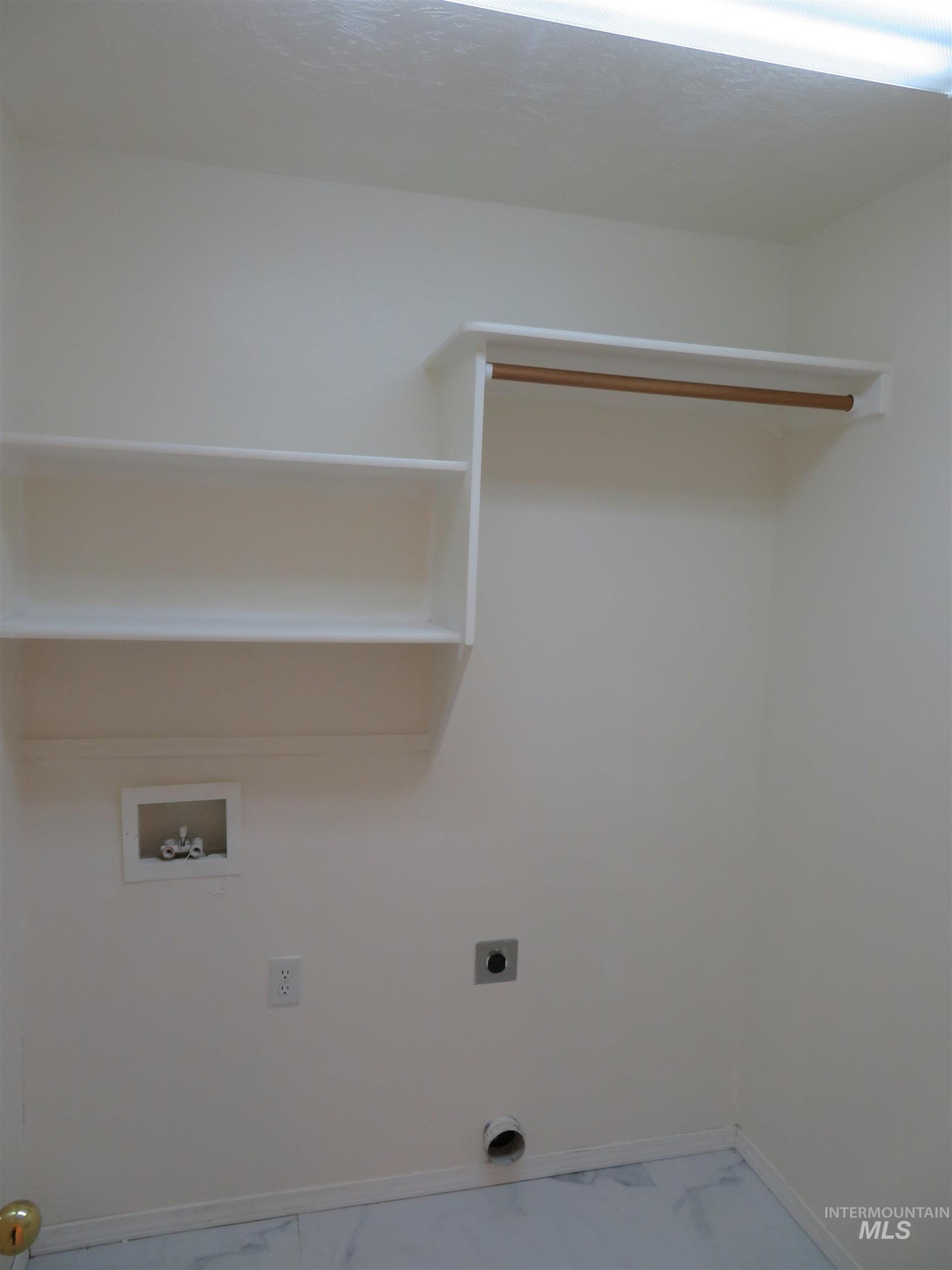 Laundry area with hookup for a washing machine, electric dryer hookup, and marble finish flooring