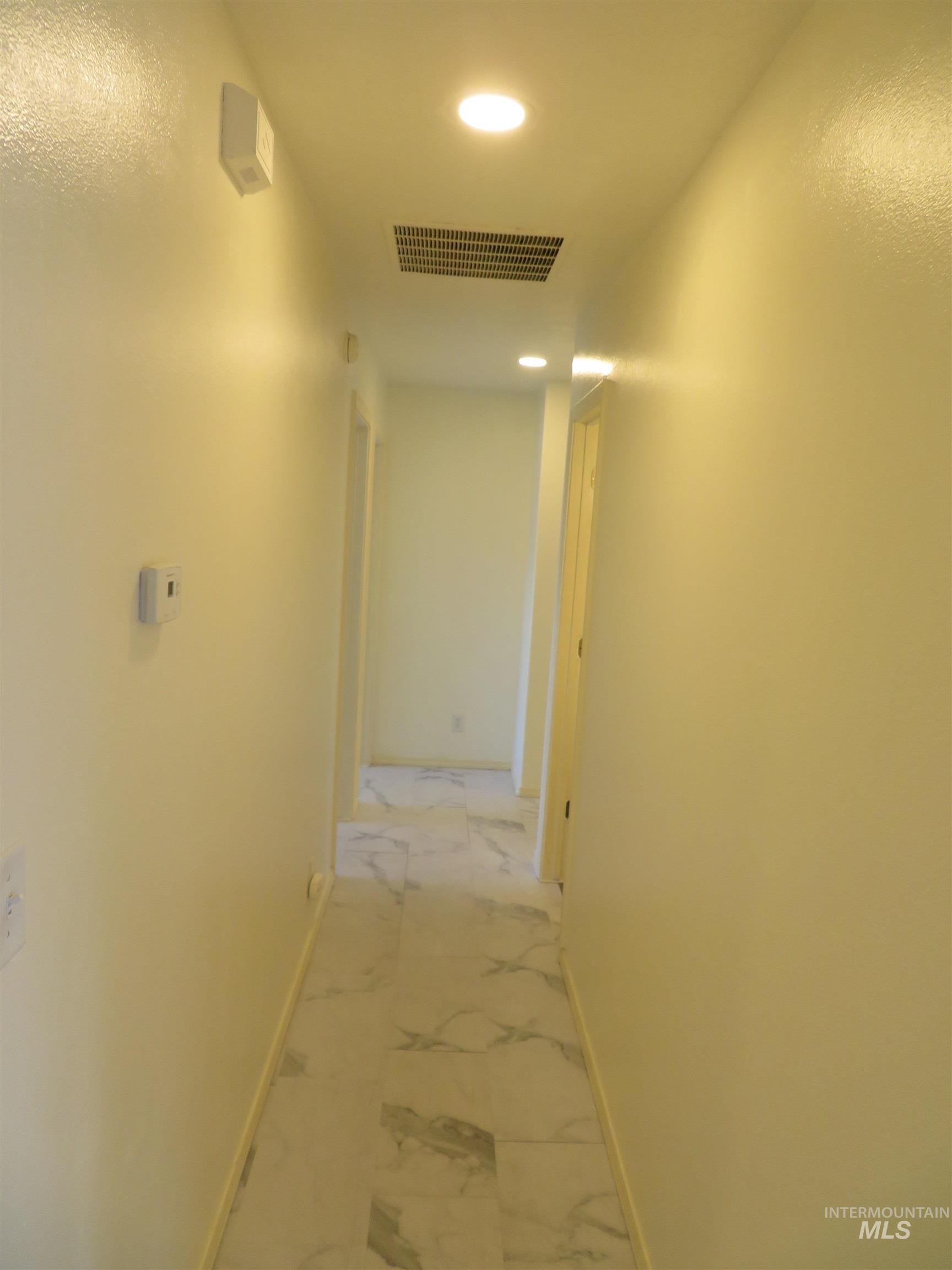 Hall with recessed lighting and light marble finish flooring