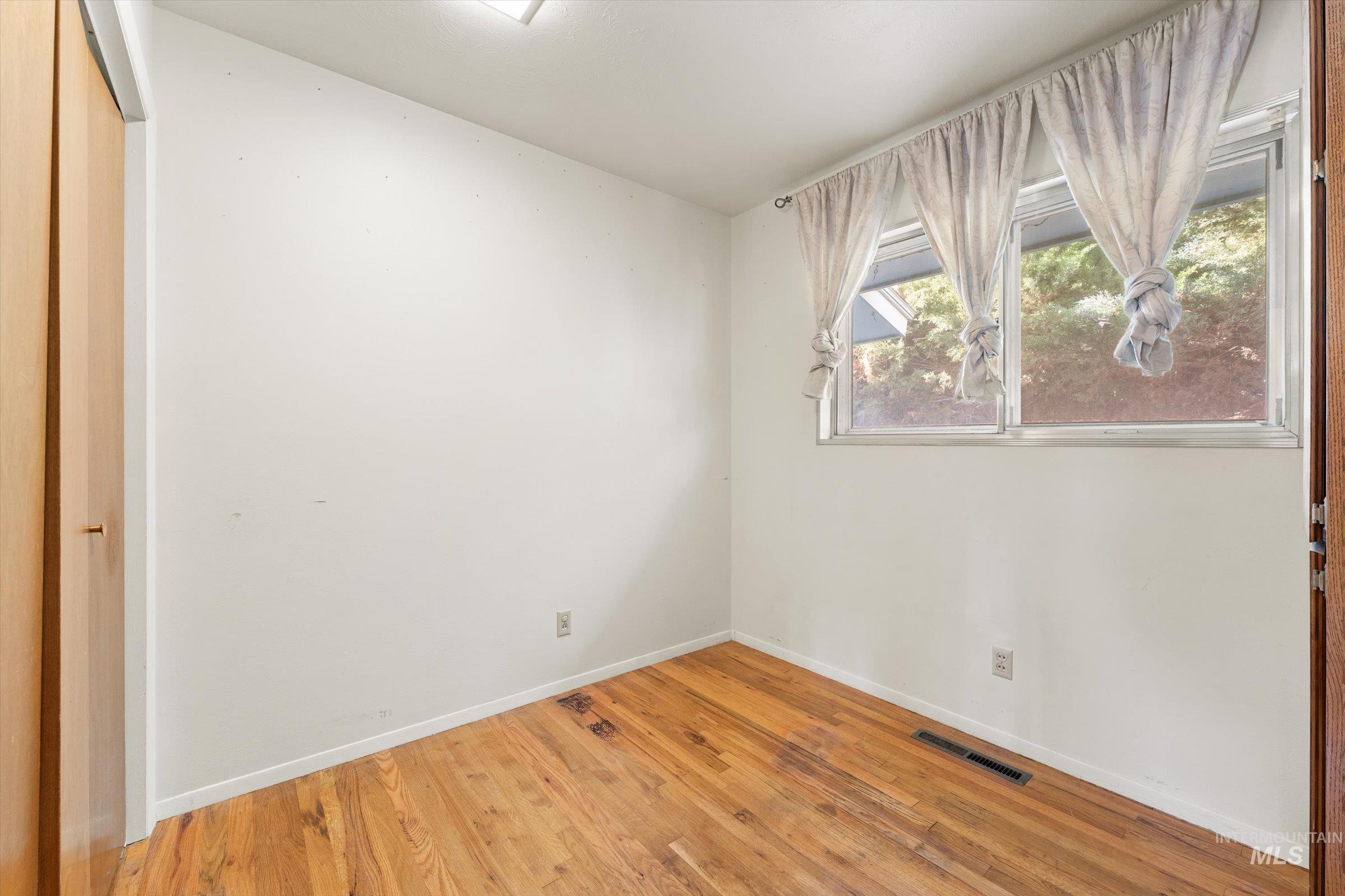 Unfurnished bedroom with light wood-style flooring and a closet