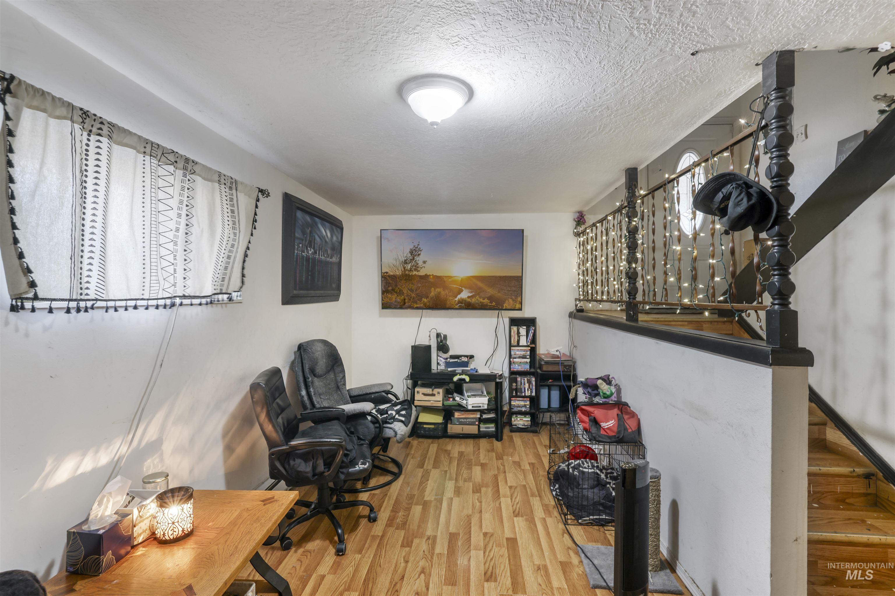 Office space with a textured ceiling and wood finished floors