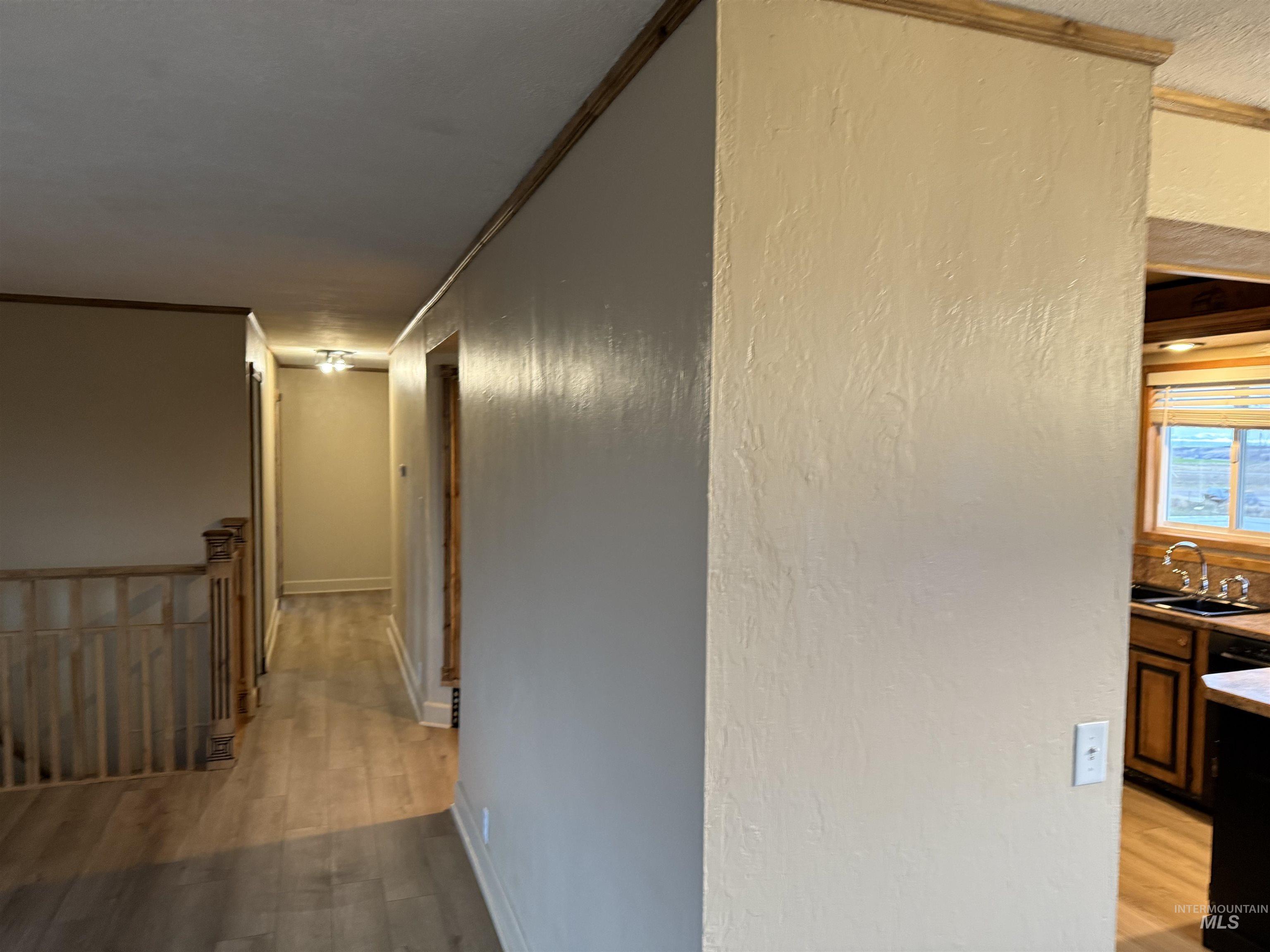 Hall featuring light wood-style flooring and crown molding