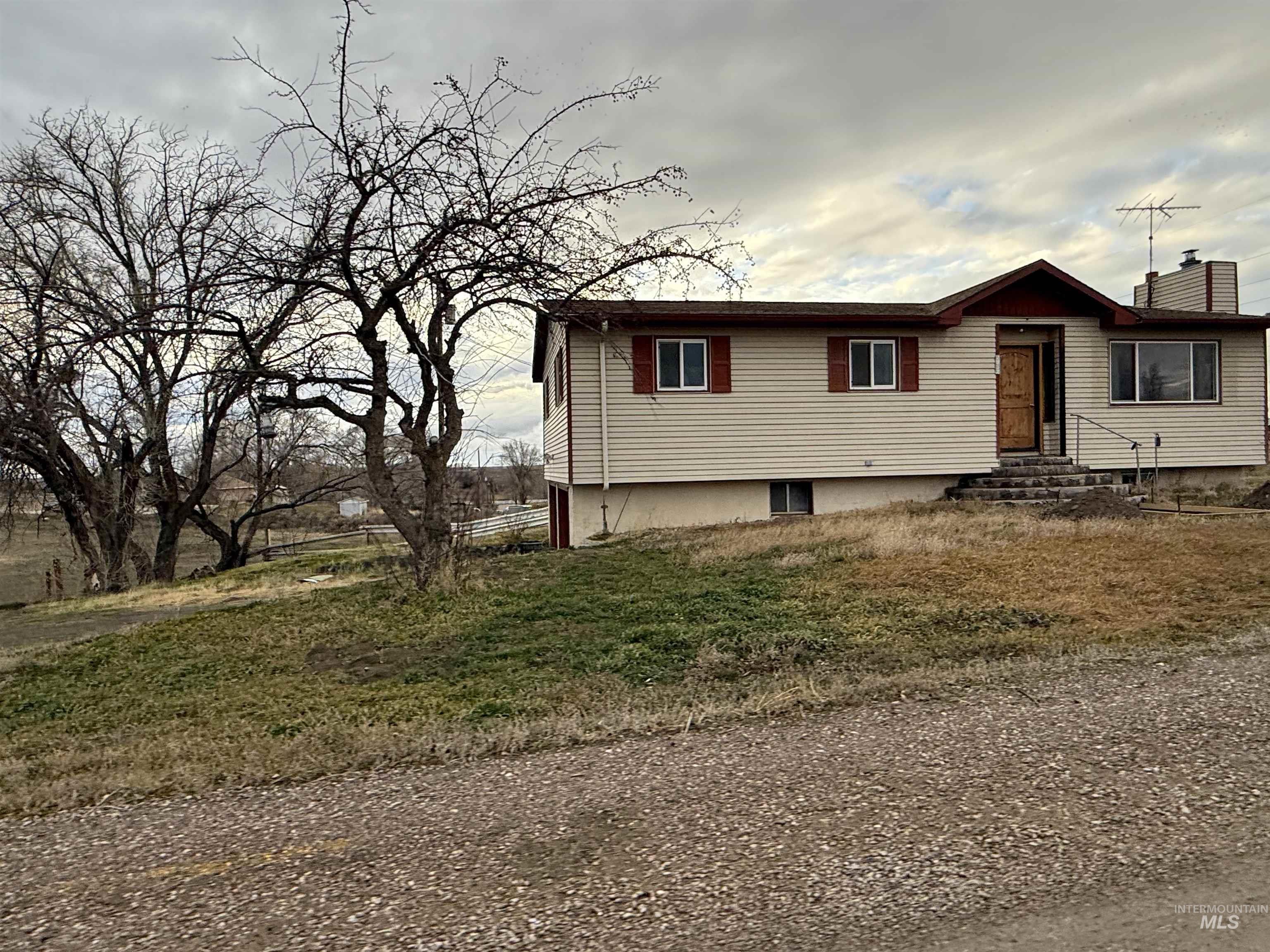 View of front of house featuring entry steps, a chimney, and a front lawn