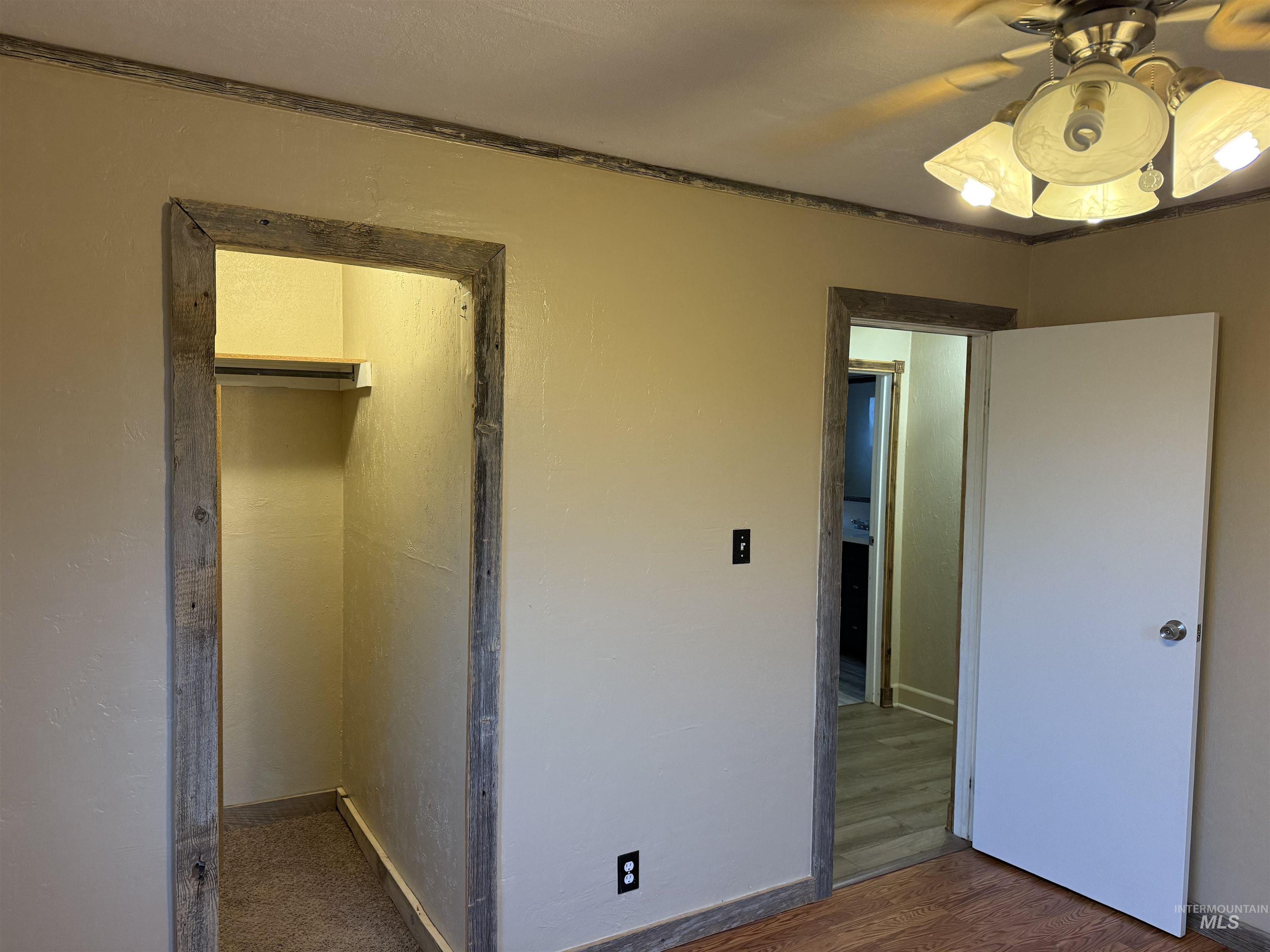 Unfurnished bedroom featuring wood finished floors and a walk in closet