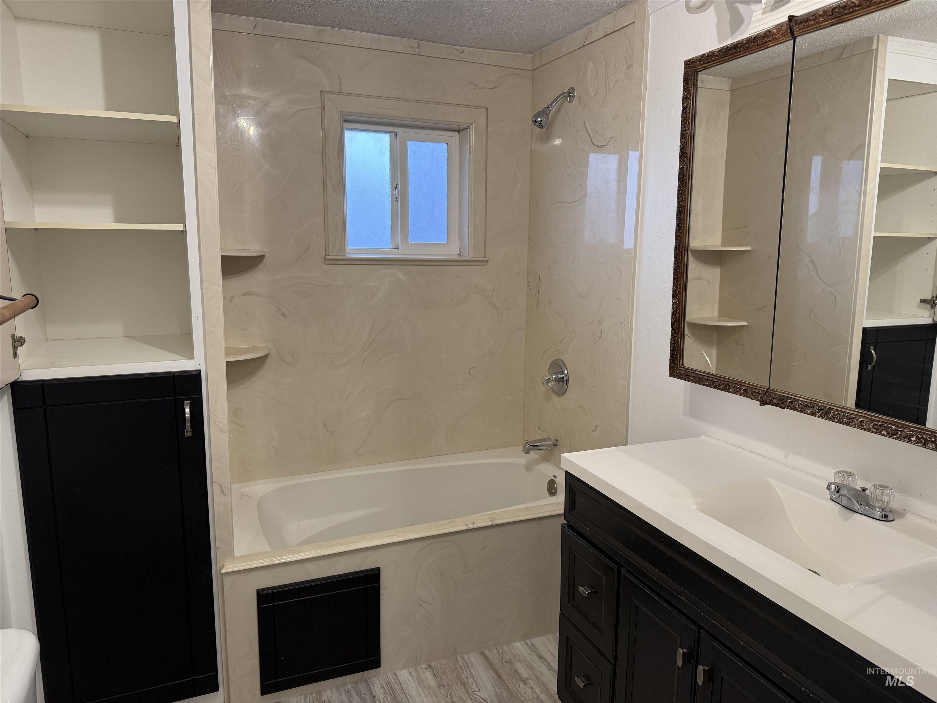 Bathroom featuring vanity, tub / shower combination, and light wood finished floors