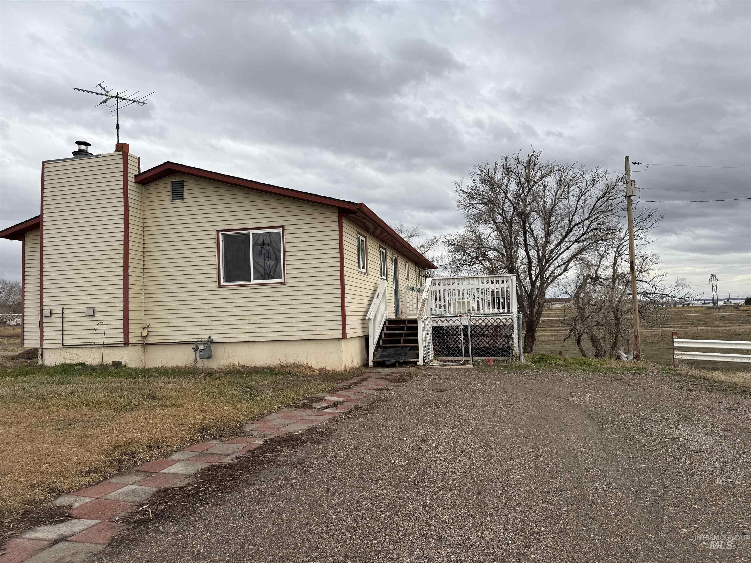 View of side of home featuring a deck, a chimney, and stairs