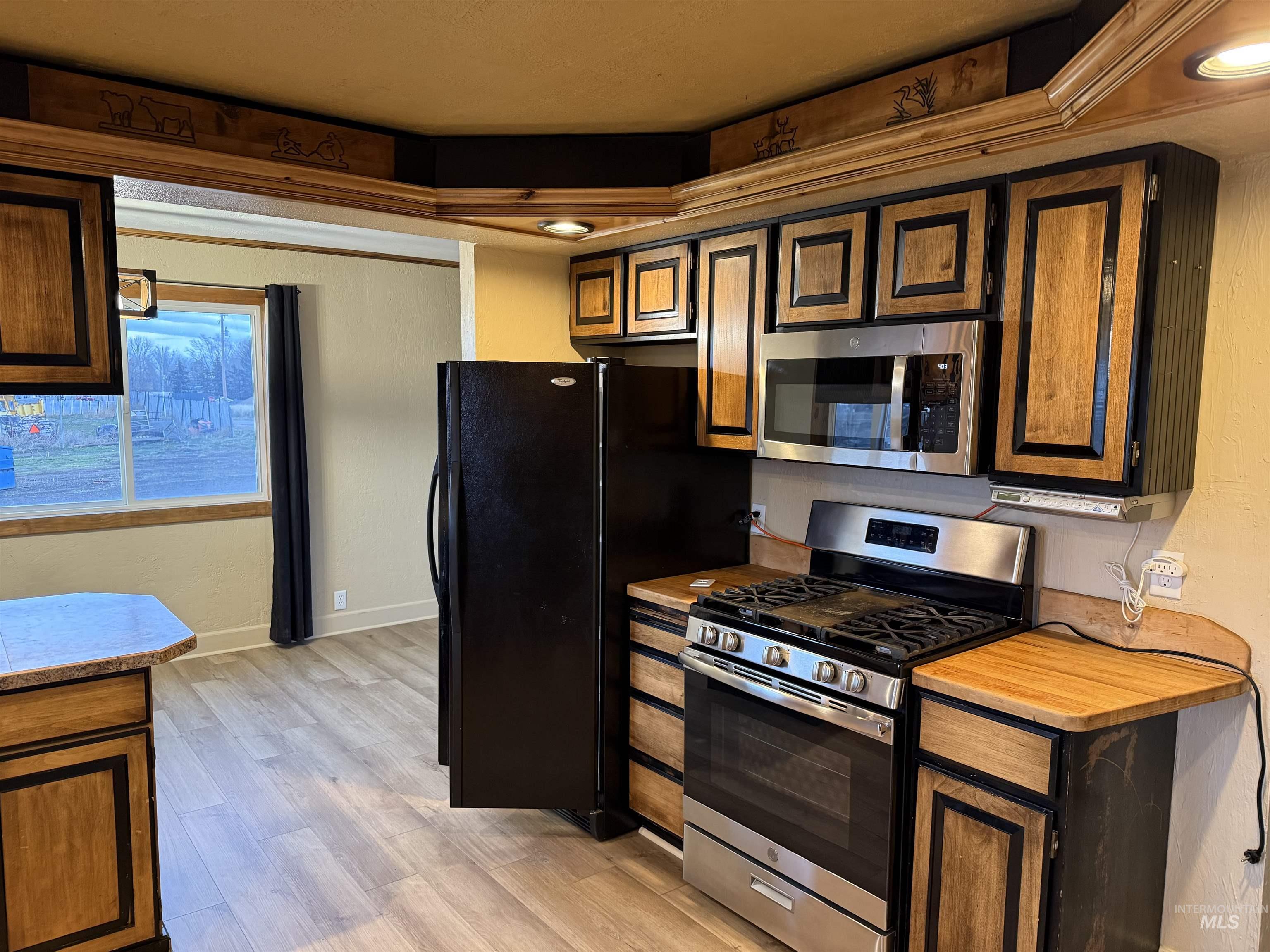 Kitchen featuring appliances with stainless steel finishes, light countertops, and light wood-style floors