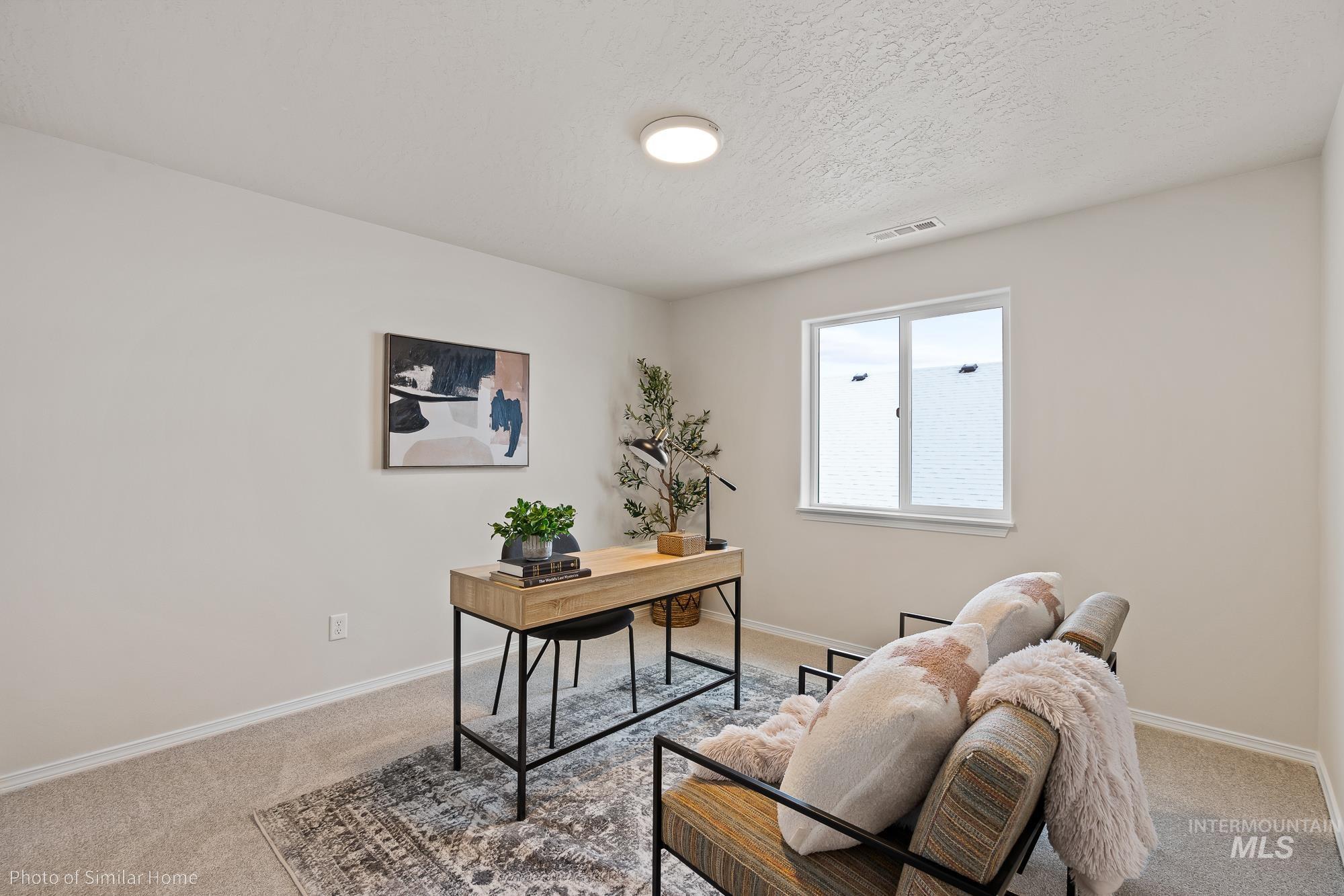 Office area with light carpet and a textured ceiling