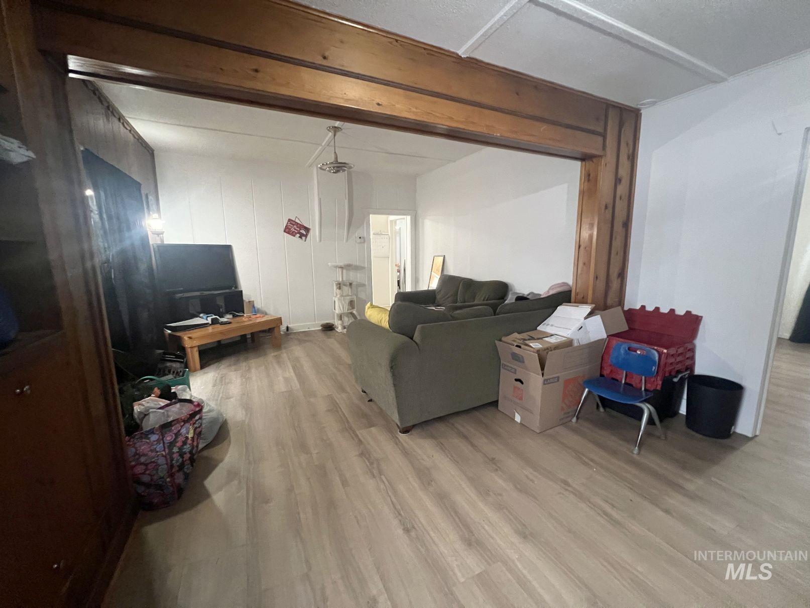 Living area featuring light wood finished floors and beamed ceiling