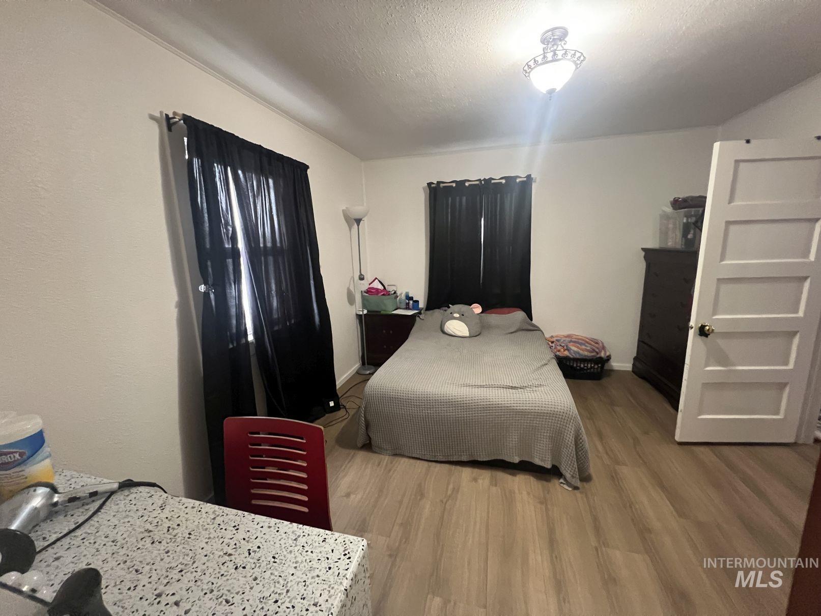 Bedroom with light wood-style flooring and a textured ceiling