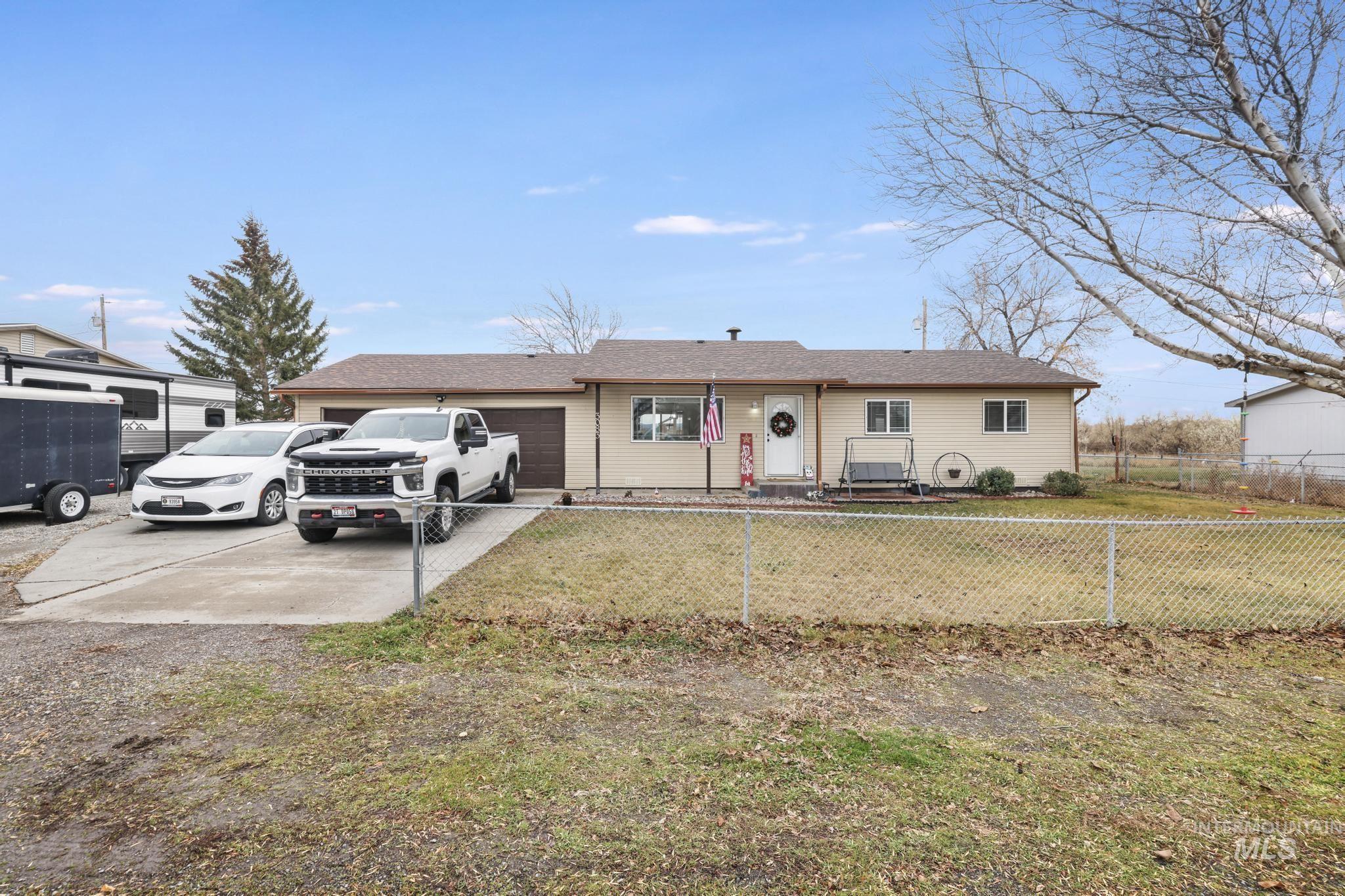 Ranch-style house featuring a fenced front yard, a garage, and concrete driveway