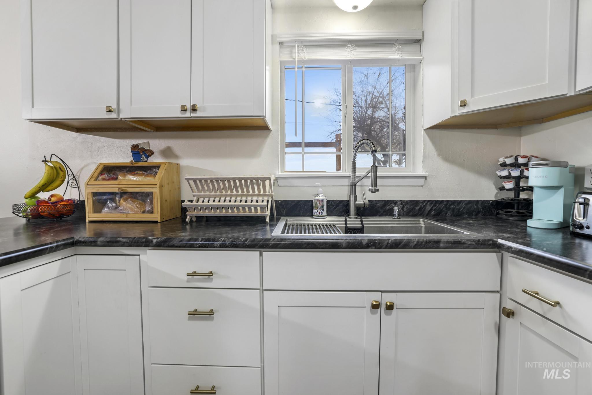 Kitchen featuring a sink and white cabinets