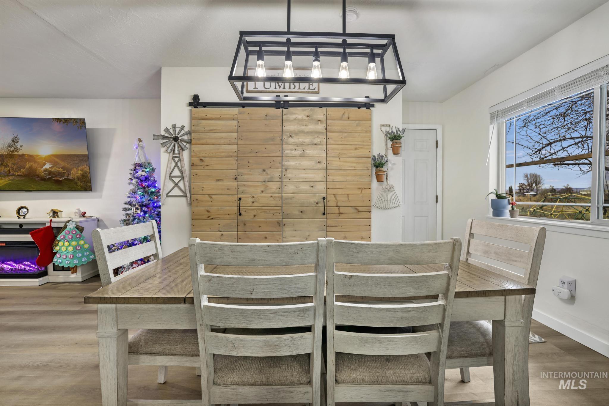 Dining room with light wood-style flooring and a barn door