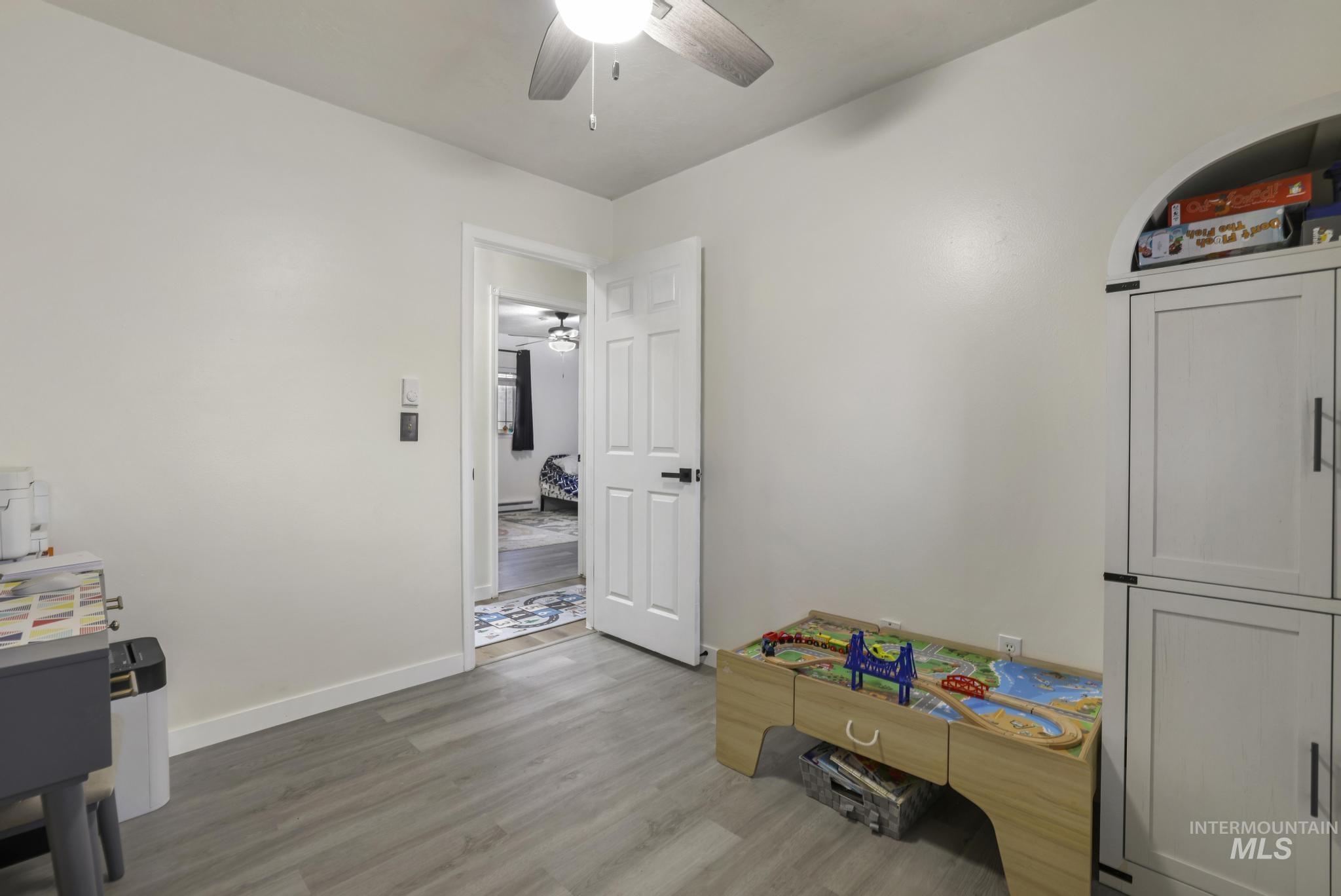 Recreation room featuring light wood-style floors and ceiling fan
