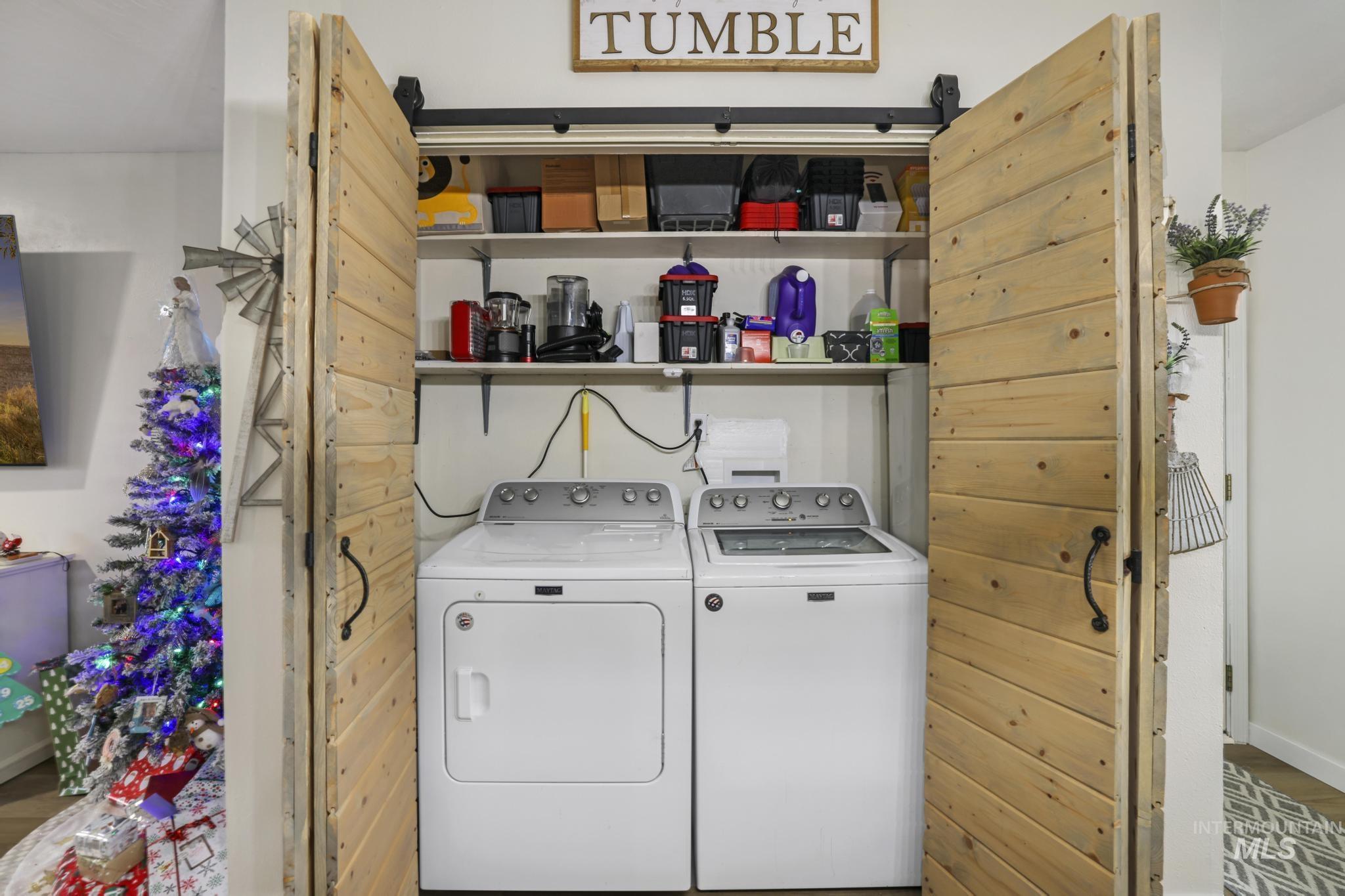 Washroom with washing machine and clothes dryer and wood finished floors