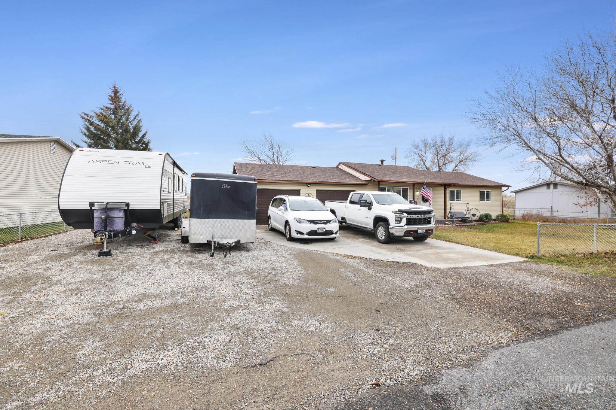 View of front of property with dirt driveway, a garage, and a front yard