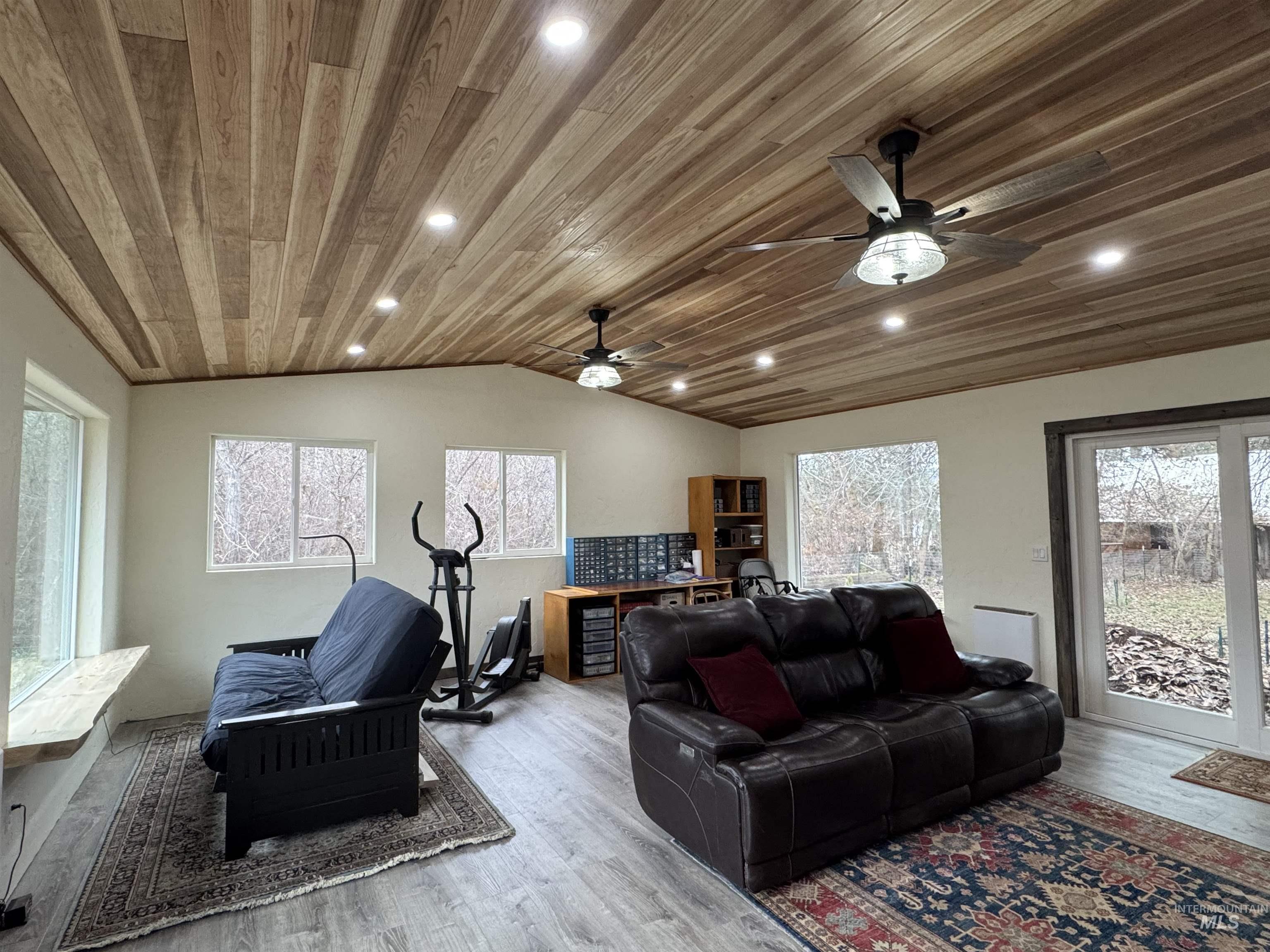 Family room off the main house, featuring lofted ceiling, wood finished floors, wooden ceiling, and recessed lighting