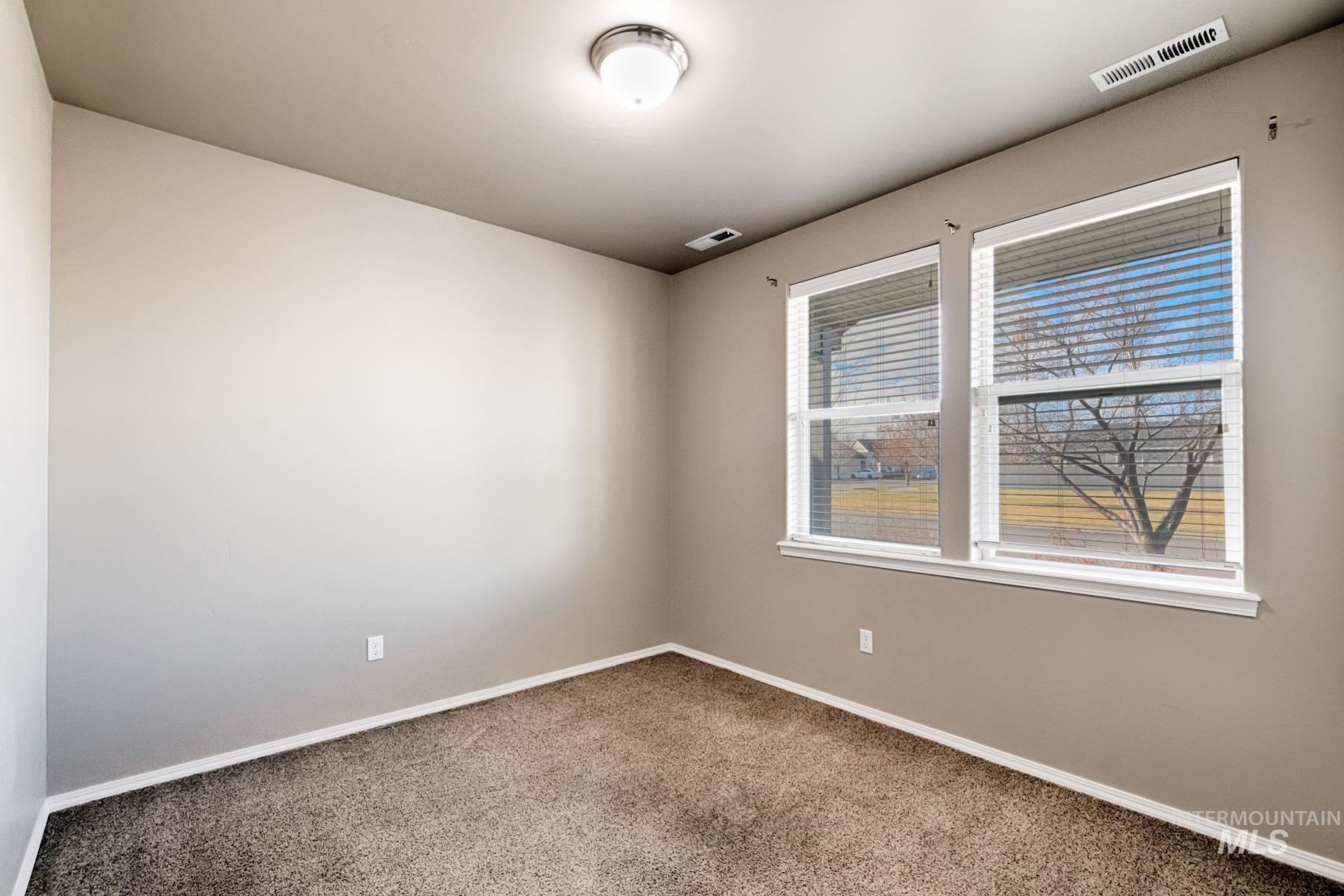 Carpeted empty room with baseboards