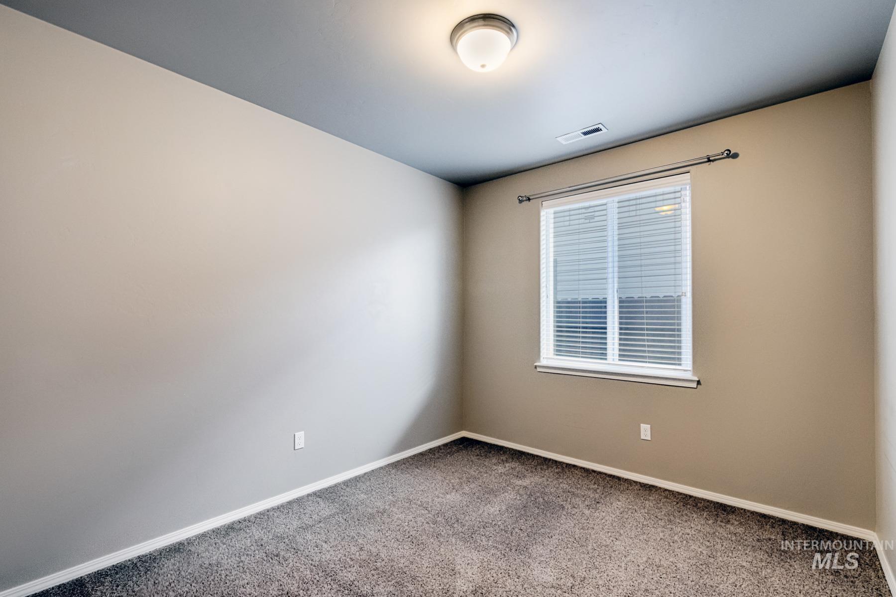 Carpeted empty room featuring baseboards