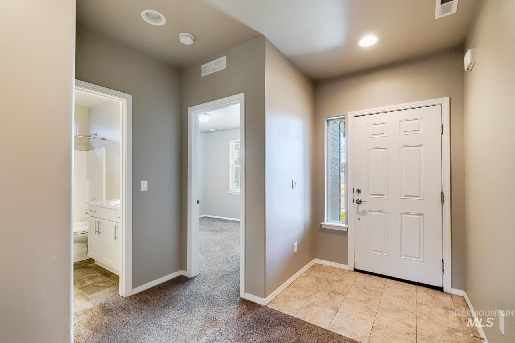 Foyer entrance featuring light carpet and recessed lighting