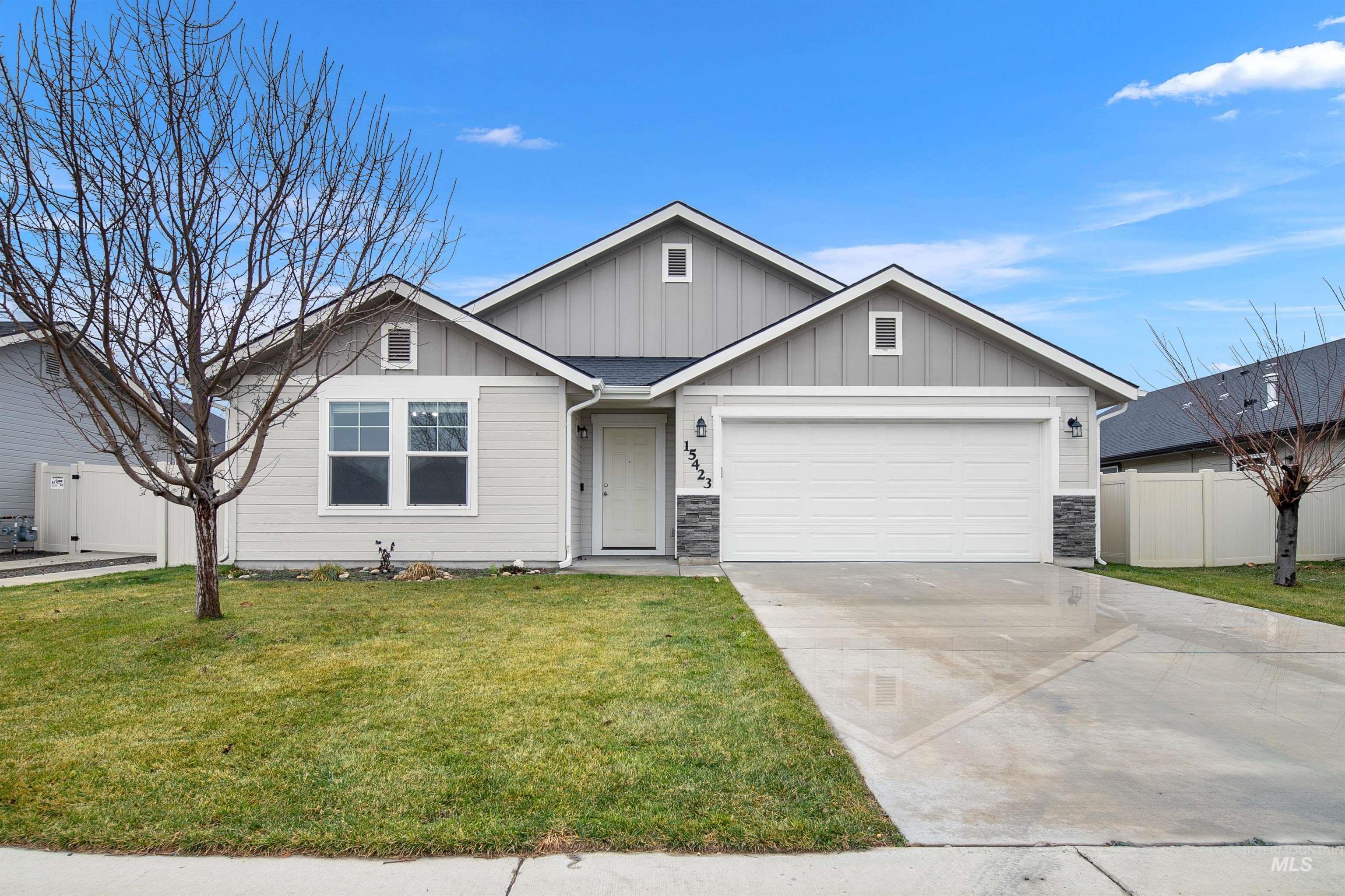 Ranch-style house featuring board and batten siding, driveway, stone siding, and an attached garage