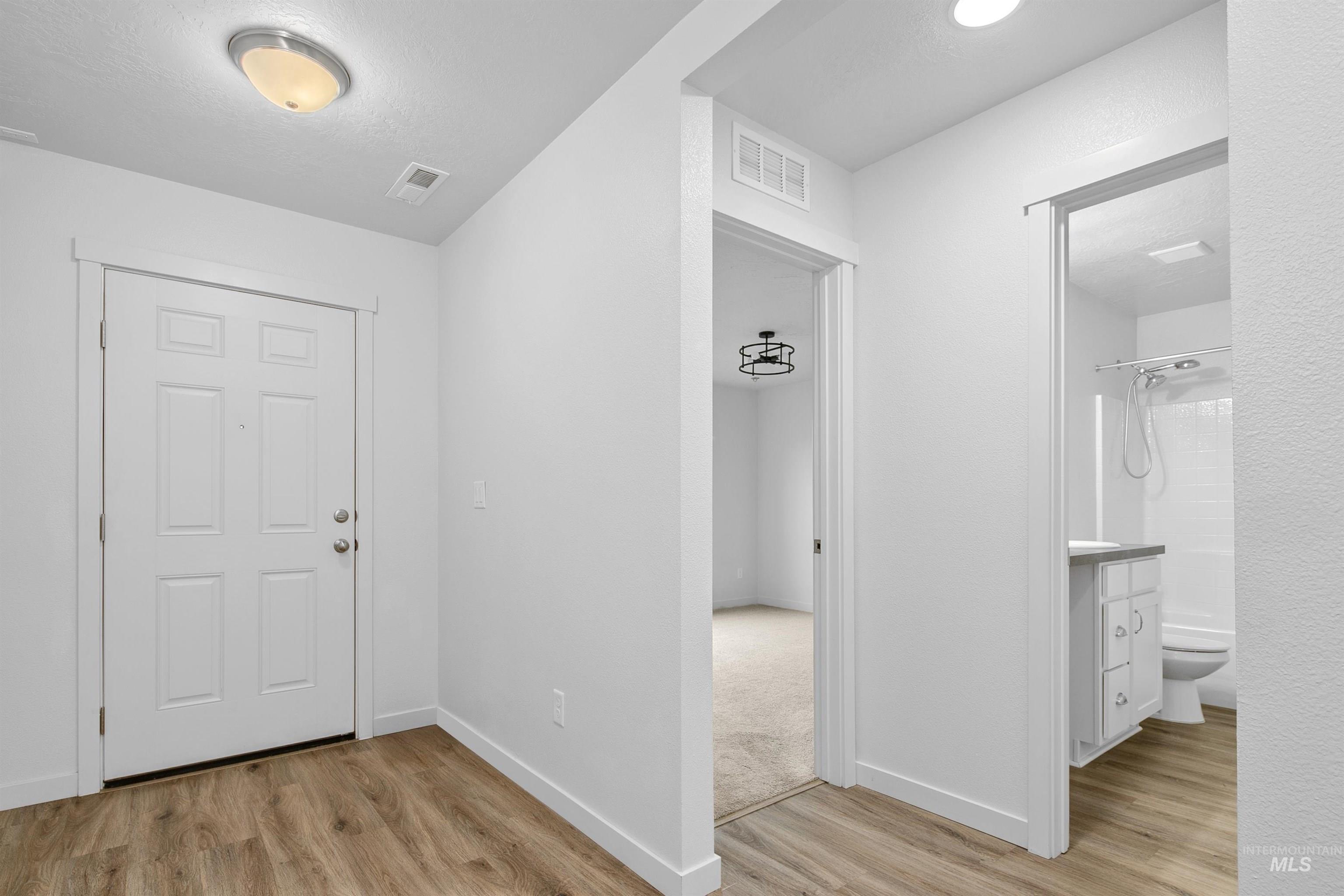 Entryway with light wood-style flooring and baseboards
