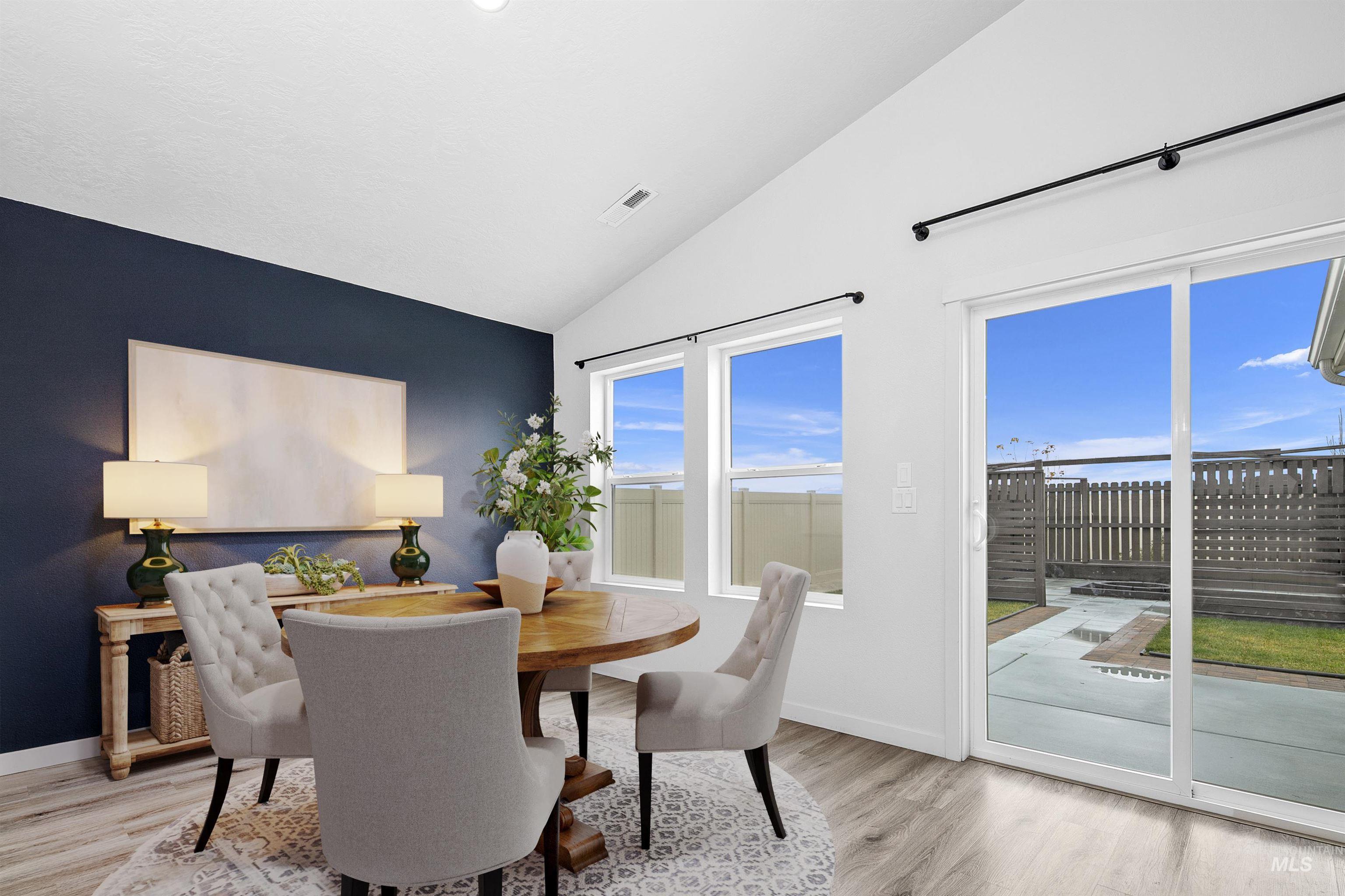 Dining area with light wood finished floors and lofted ceiling
