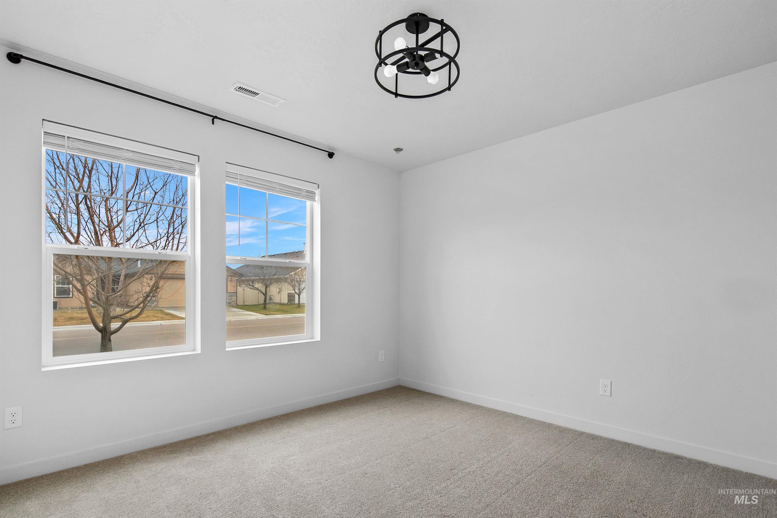 Empty room with light carpet and baseboards
