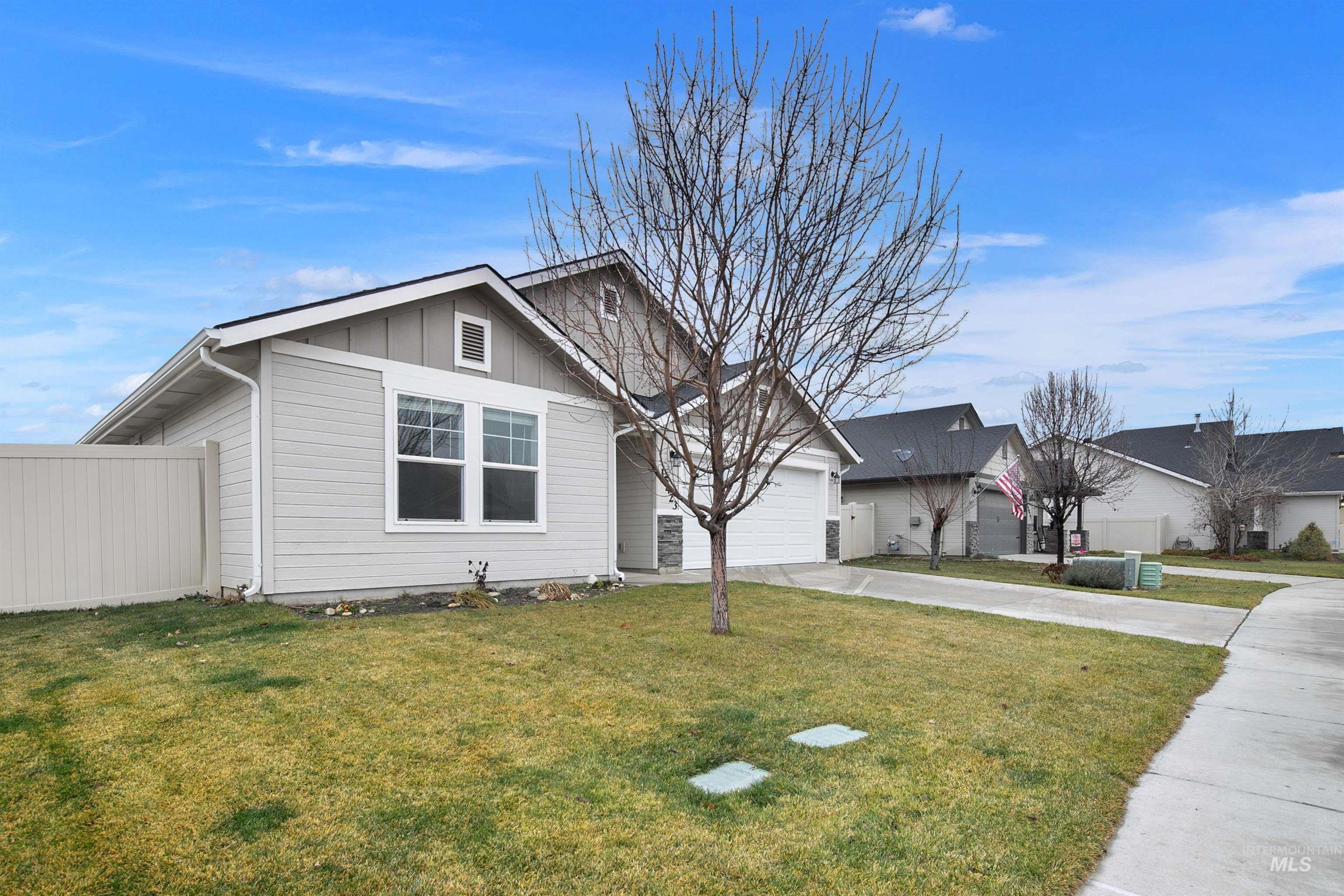 View of front facade with board and batten siding, driveway, and a garage